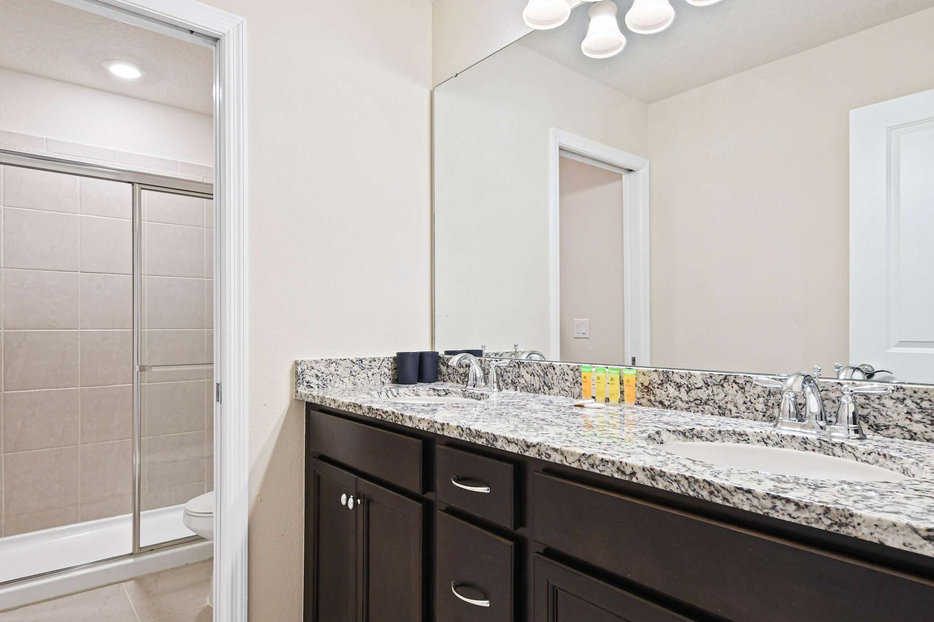 Stylish bathroom with granite double vanity and a sleek walk-in glass shower.