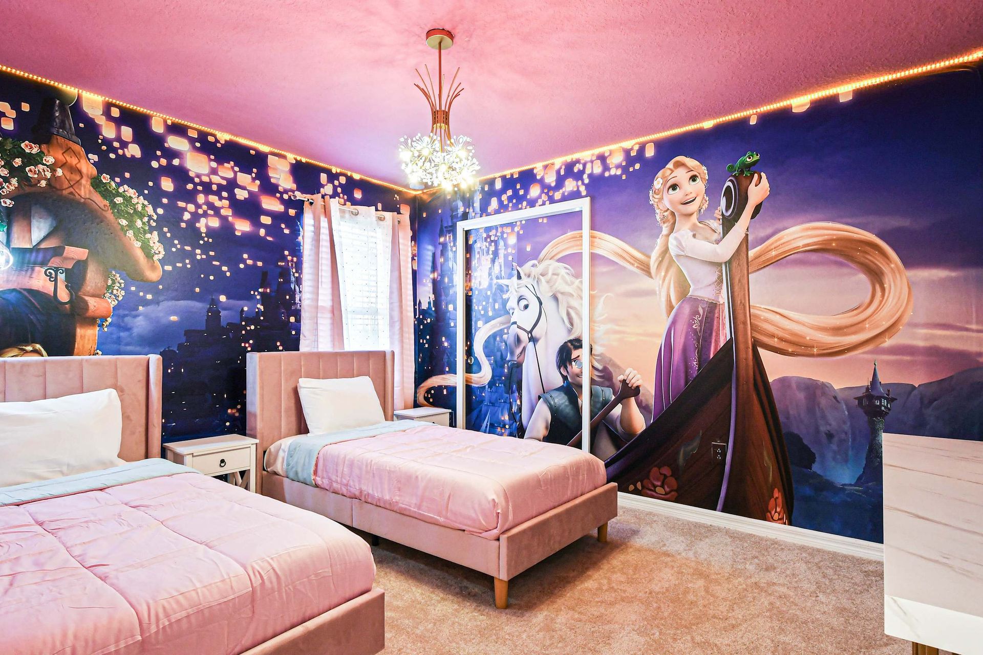Whimsical princess-themed room with twin beds, dreamy murals, and pink charm.