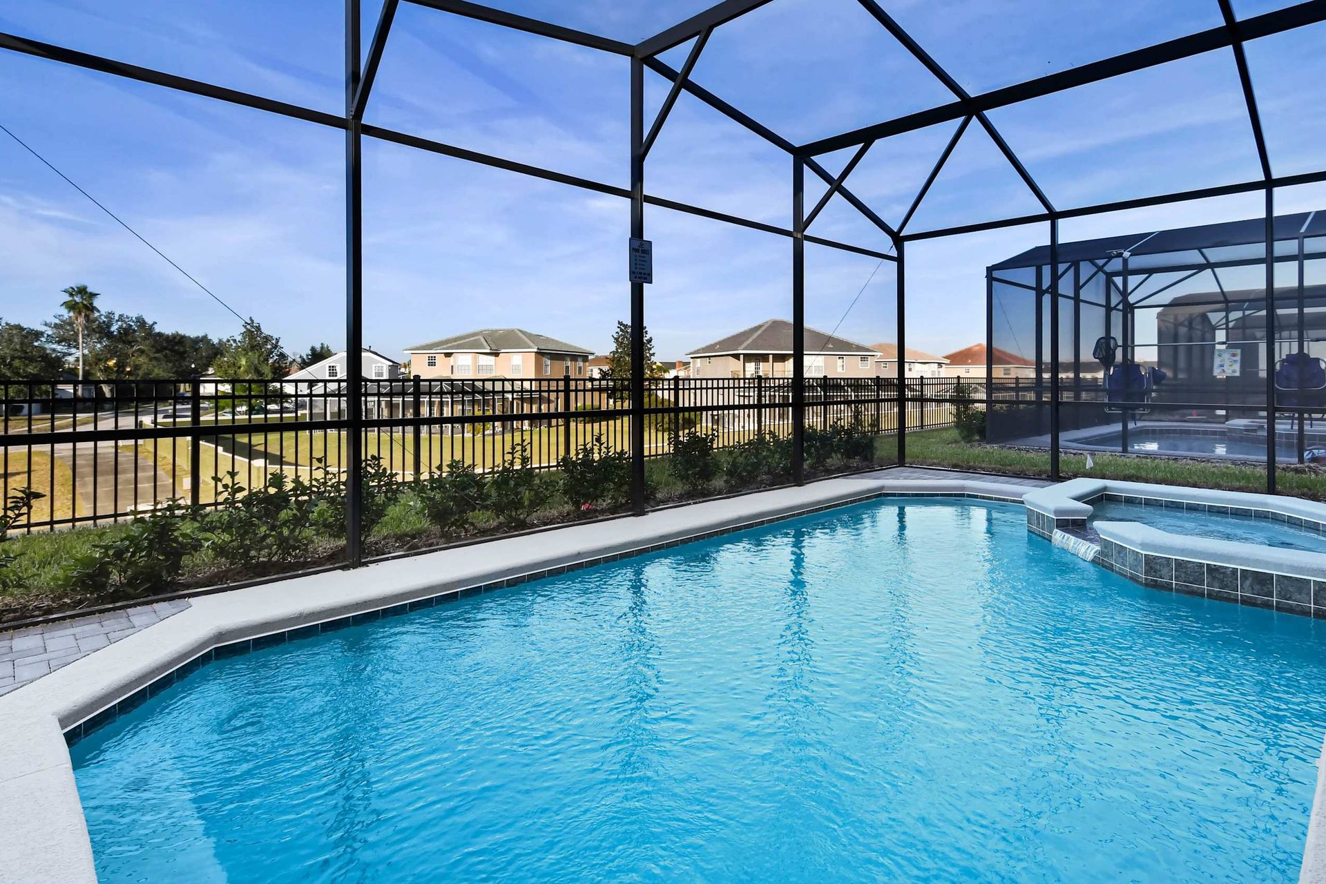 Private screened-in pool and spa with sunny views, perfect for relaxing days.