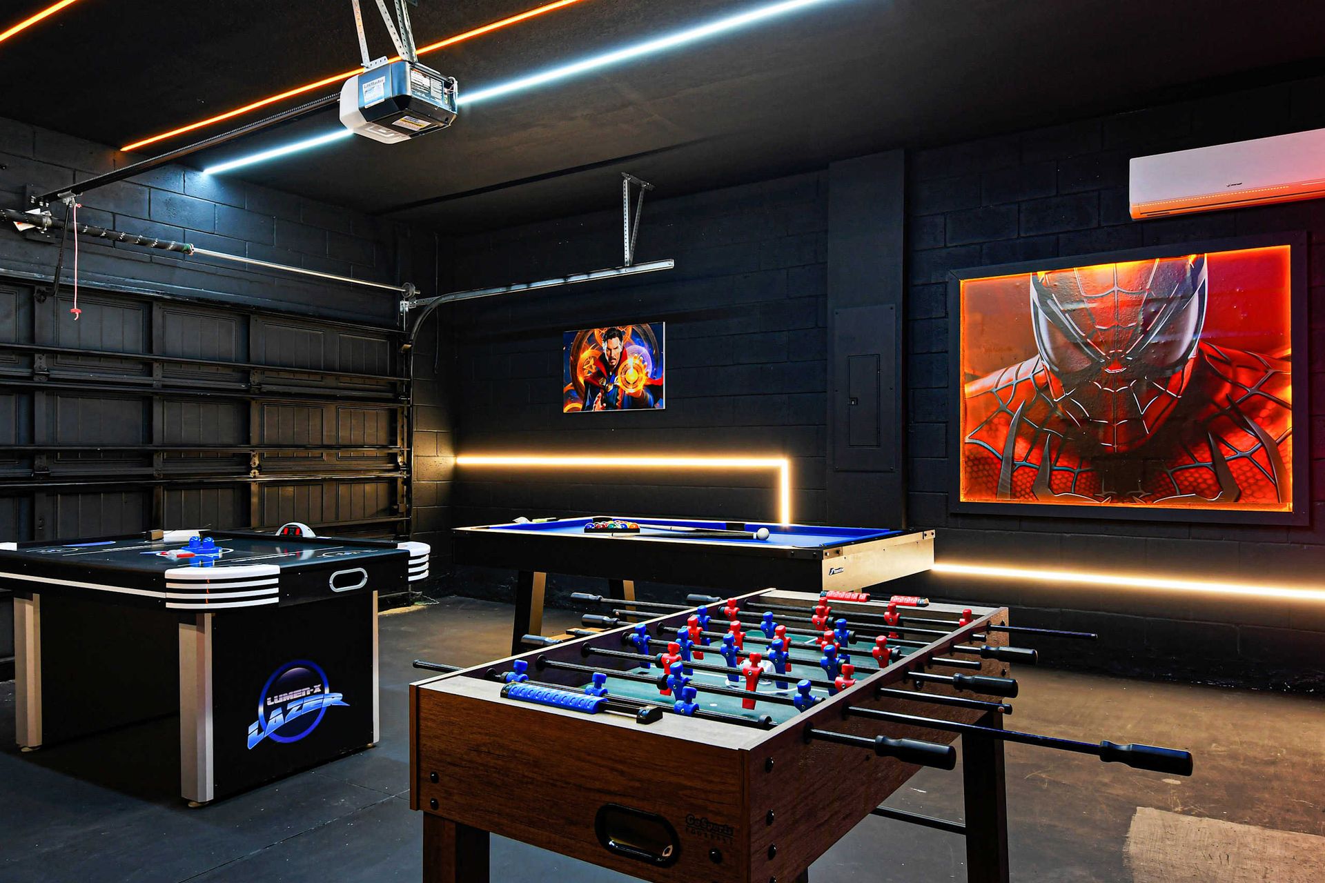 Superhero-themed game garage with foosball, pool, air hockey, and bold art.