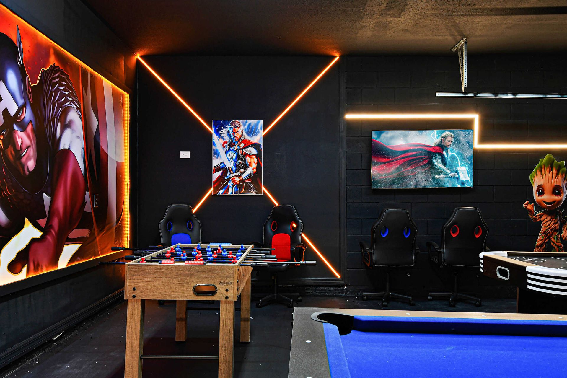 Superhero-inspired game zone with foosball, arcade seating, and bold wall art.