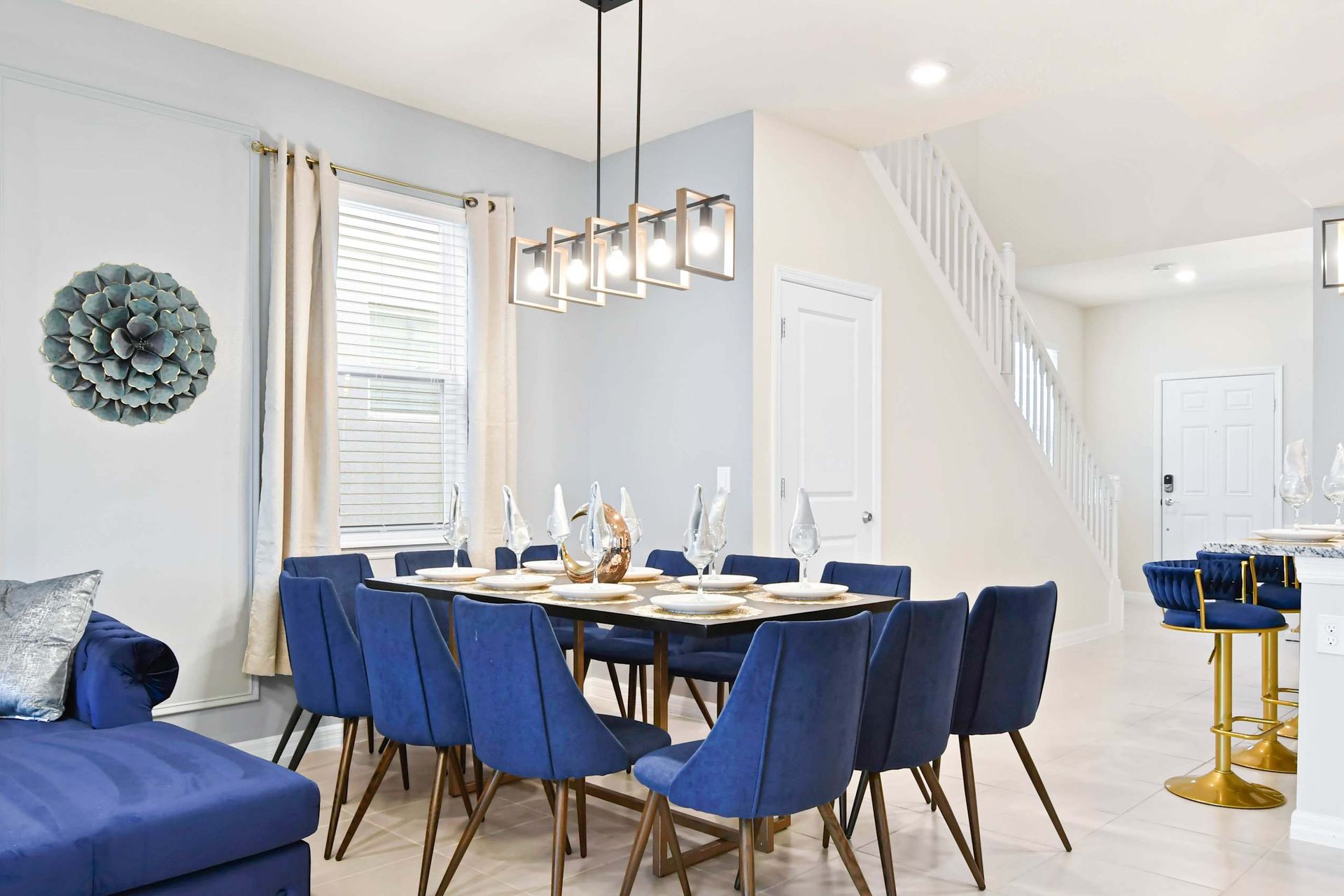 Elegant dining area with velvet navy chairs, modern lighting, and stylish flair.