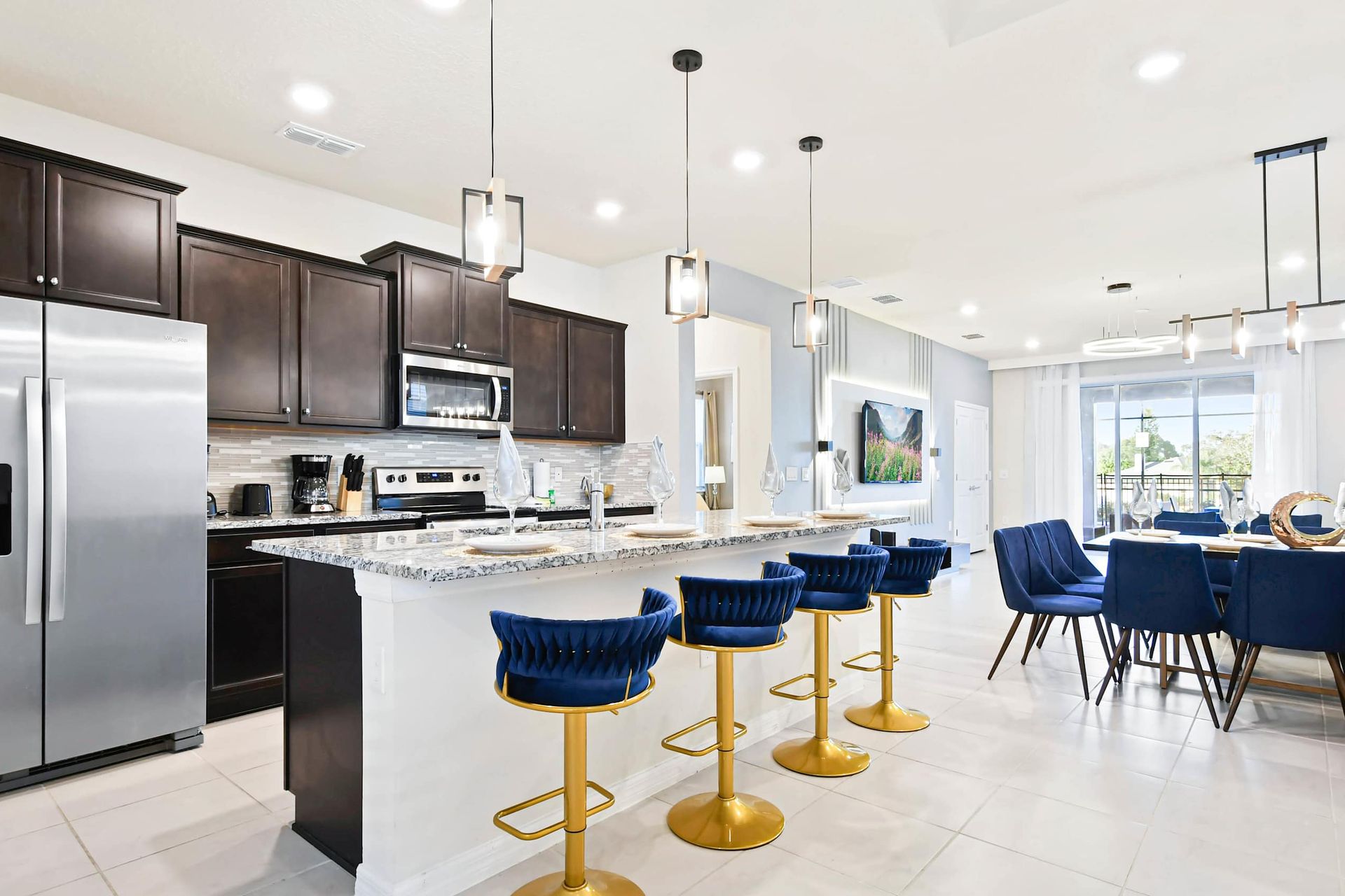 Gourmet kitchen with granite island, luxe bar stools, and open-concept layout.