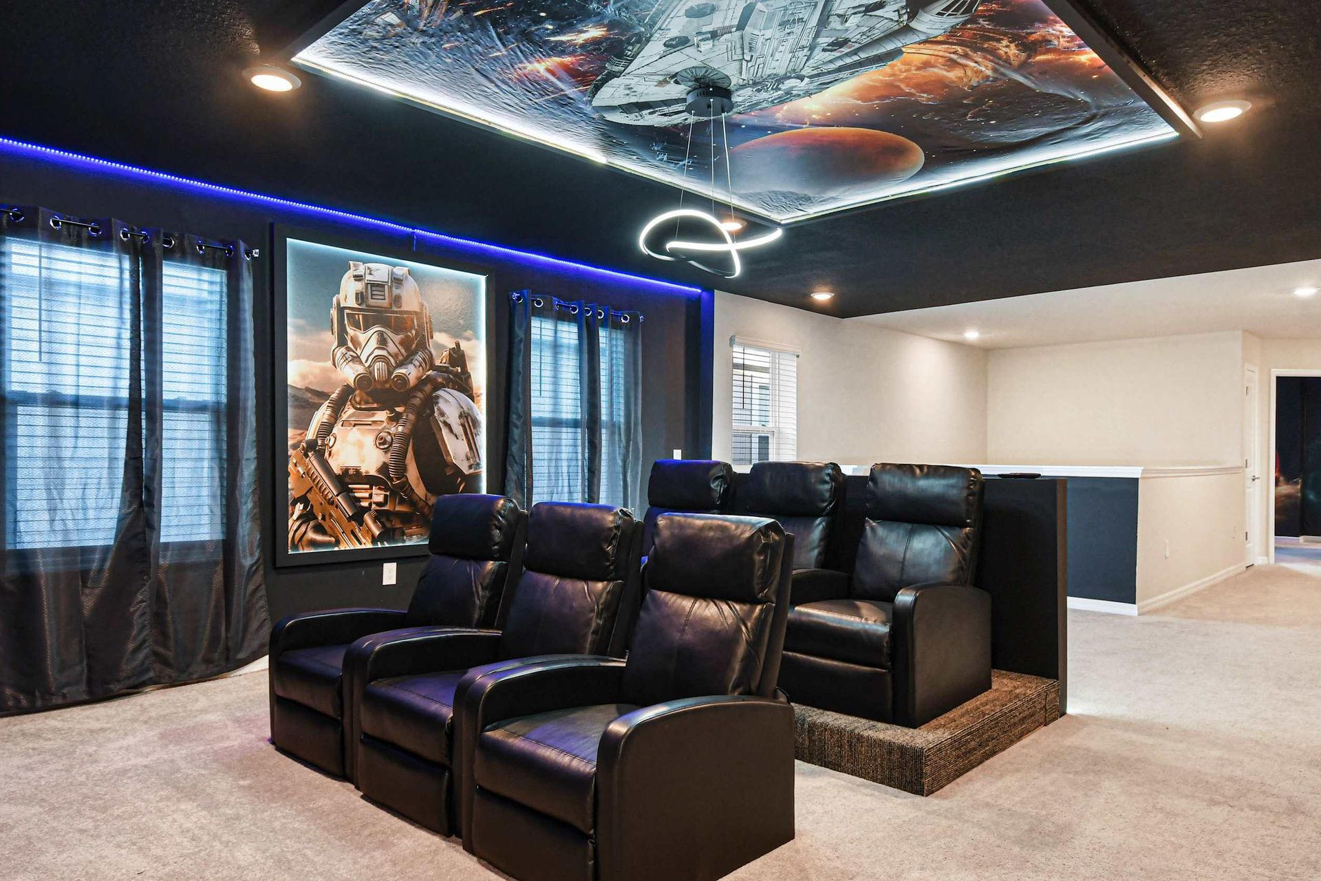 Cinematic space-themed theater with tiered leather seating and LED lighting.