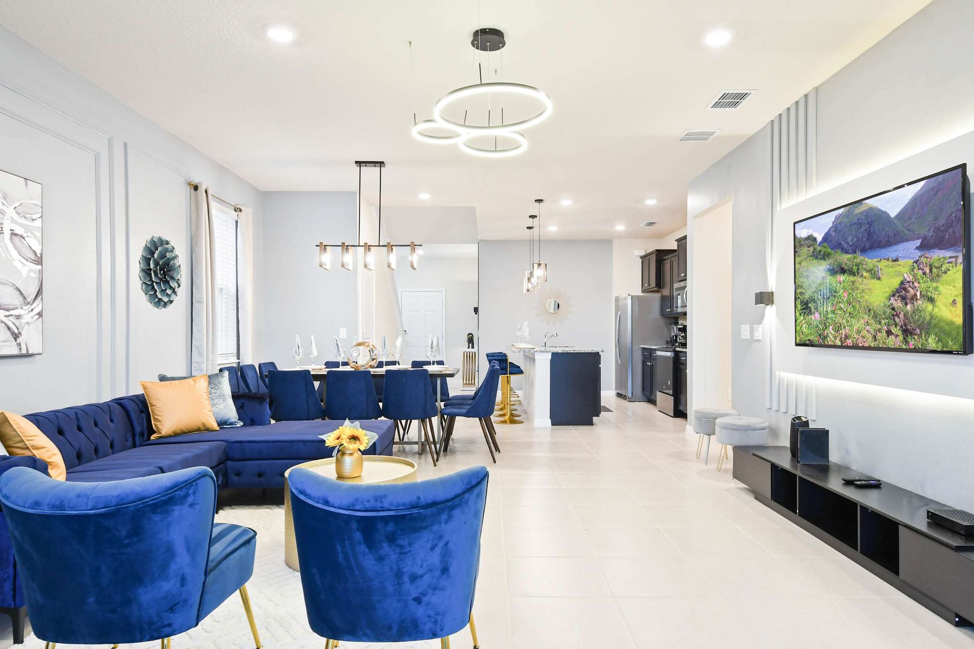 Modern open-concept living with luxe navy seating, sleek kitchen, and style.