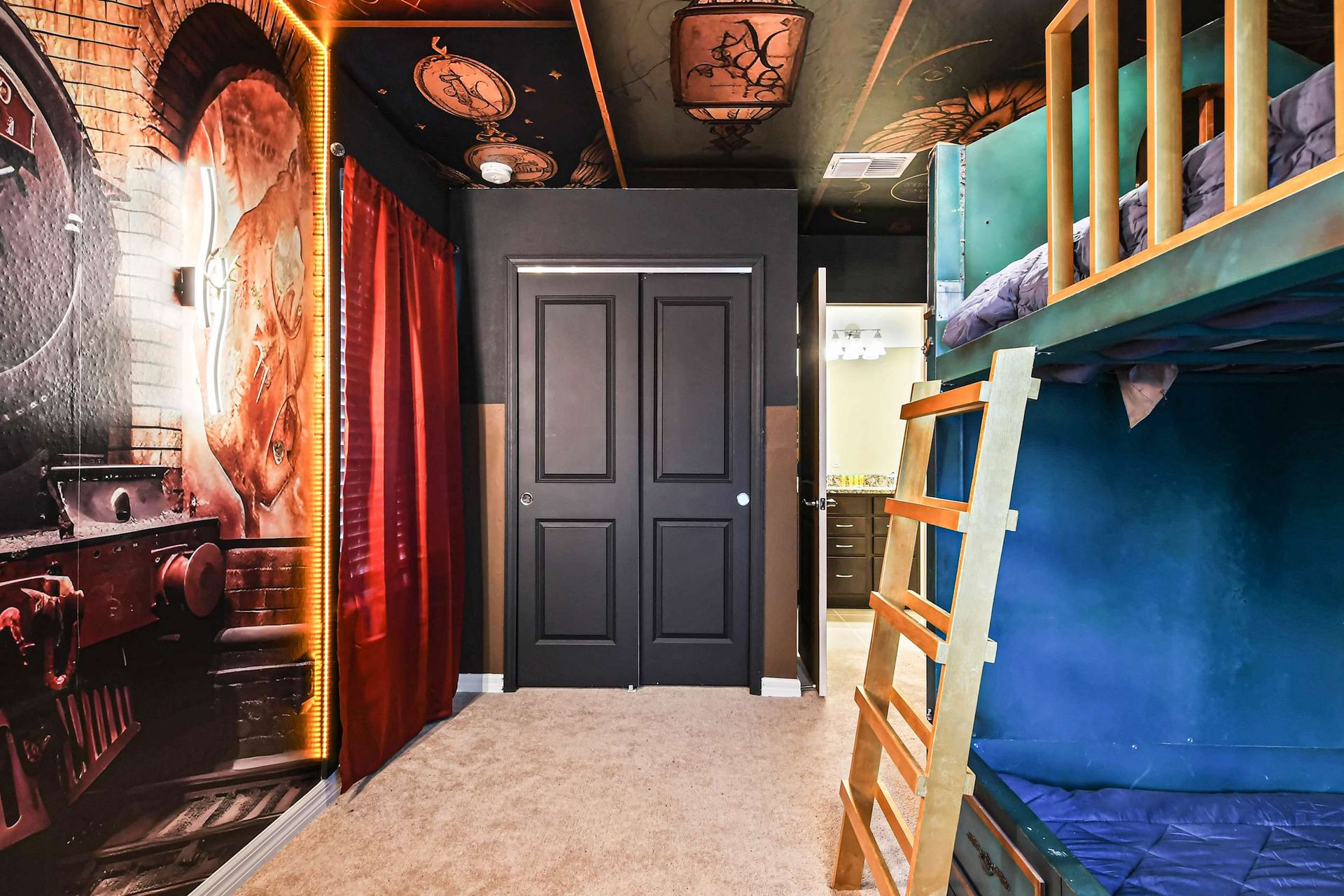 Magical train-themed bunk room with whimsical murals and cozy sleeping space.
