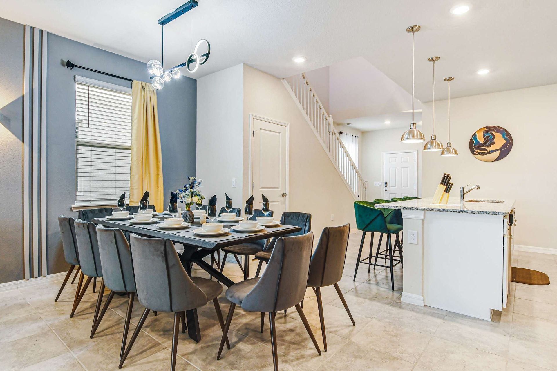Sleek dining and kitchen space with modern lighting and bar seating for four.