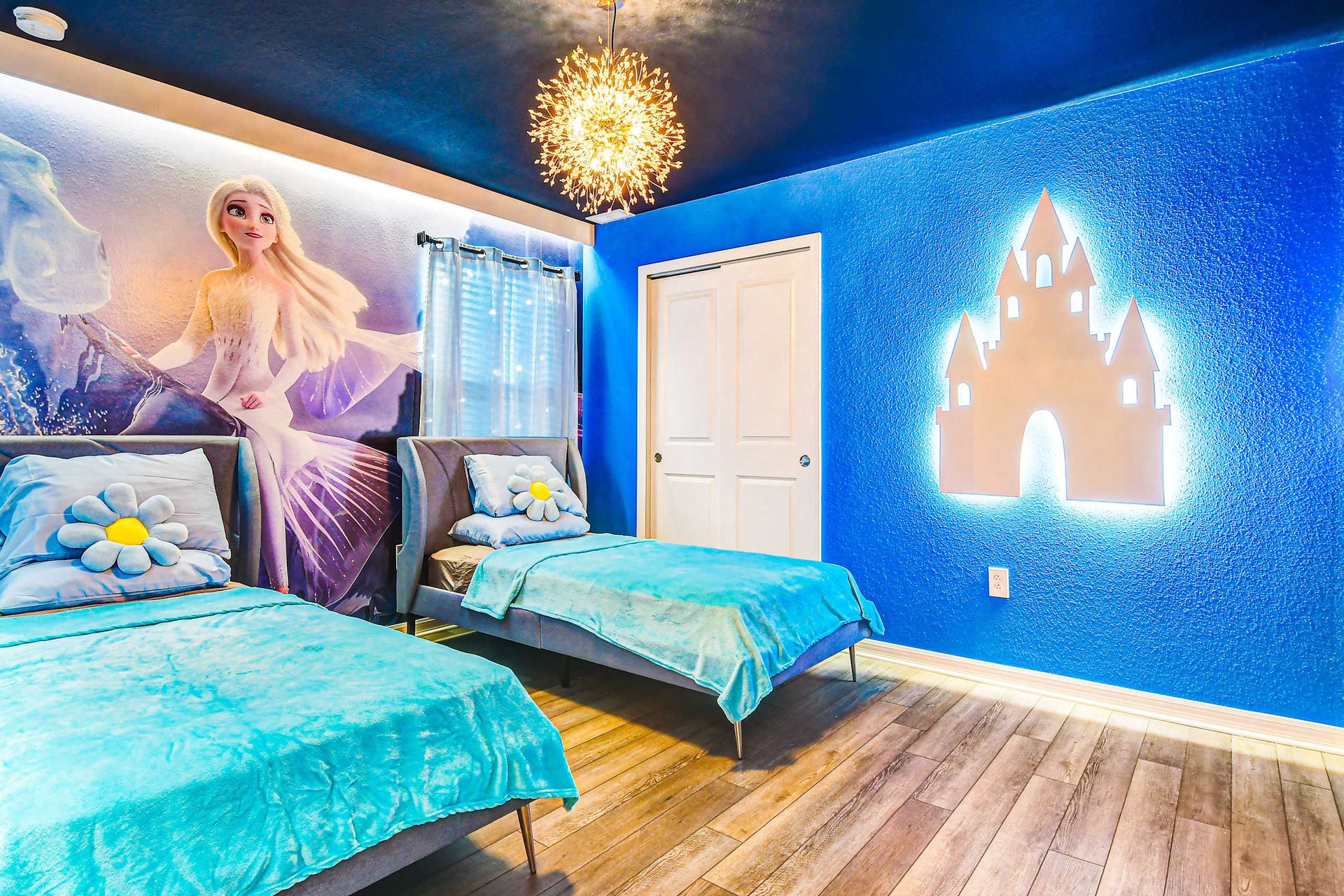 Frozen dream room with glowing castle, icy mural, and cozy twin beds for kids.