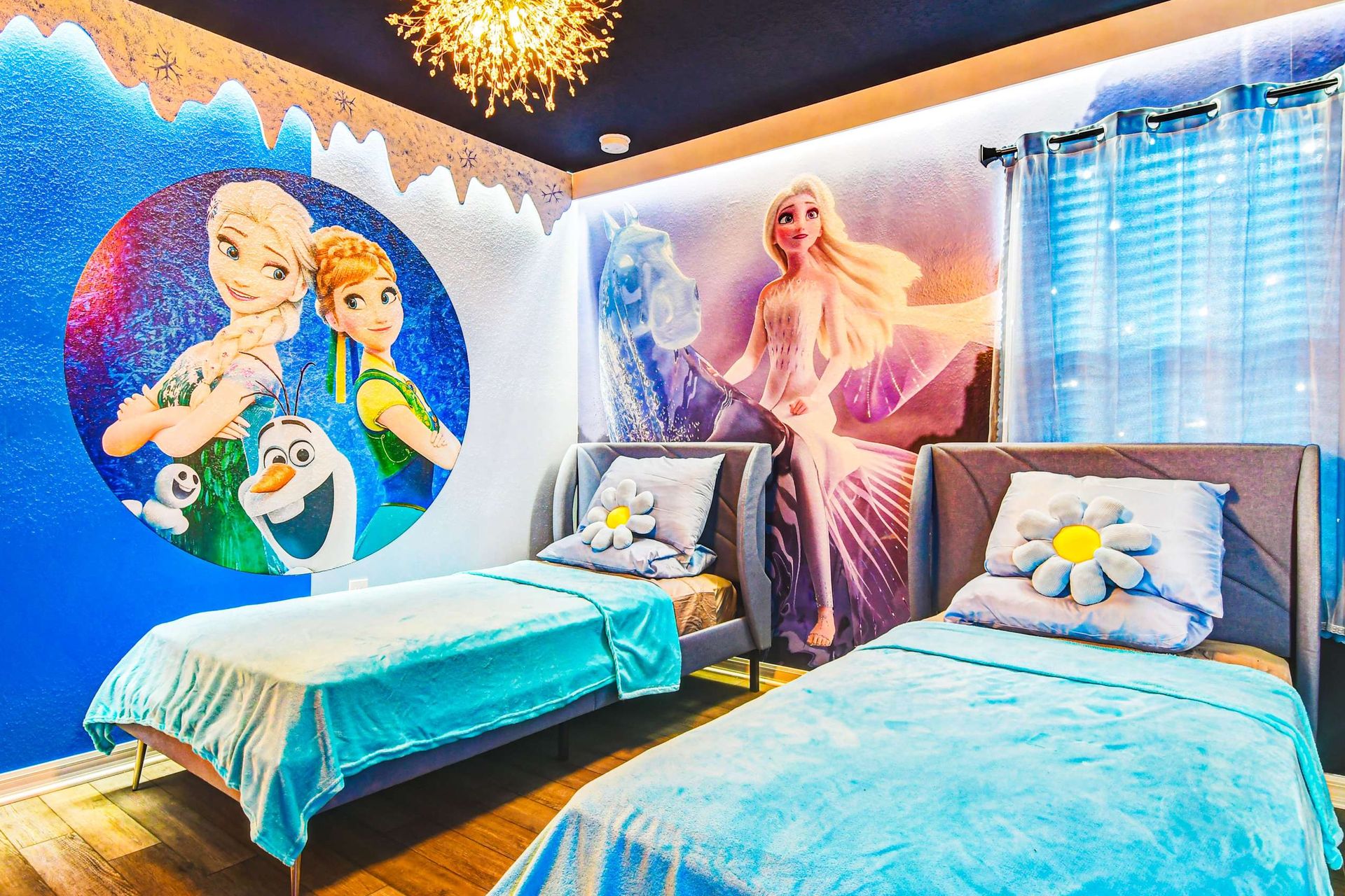 Whimsical Frozen-themed room with icy murals, cozy beds, and snowflake charm.