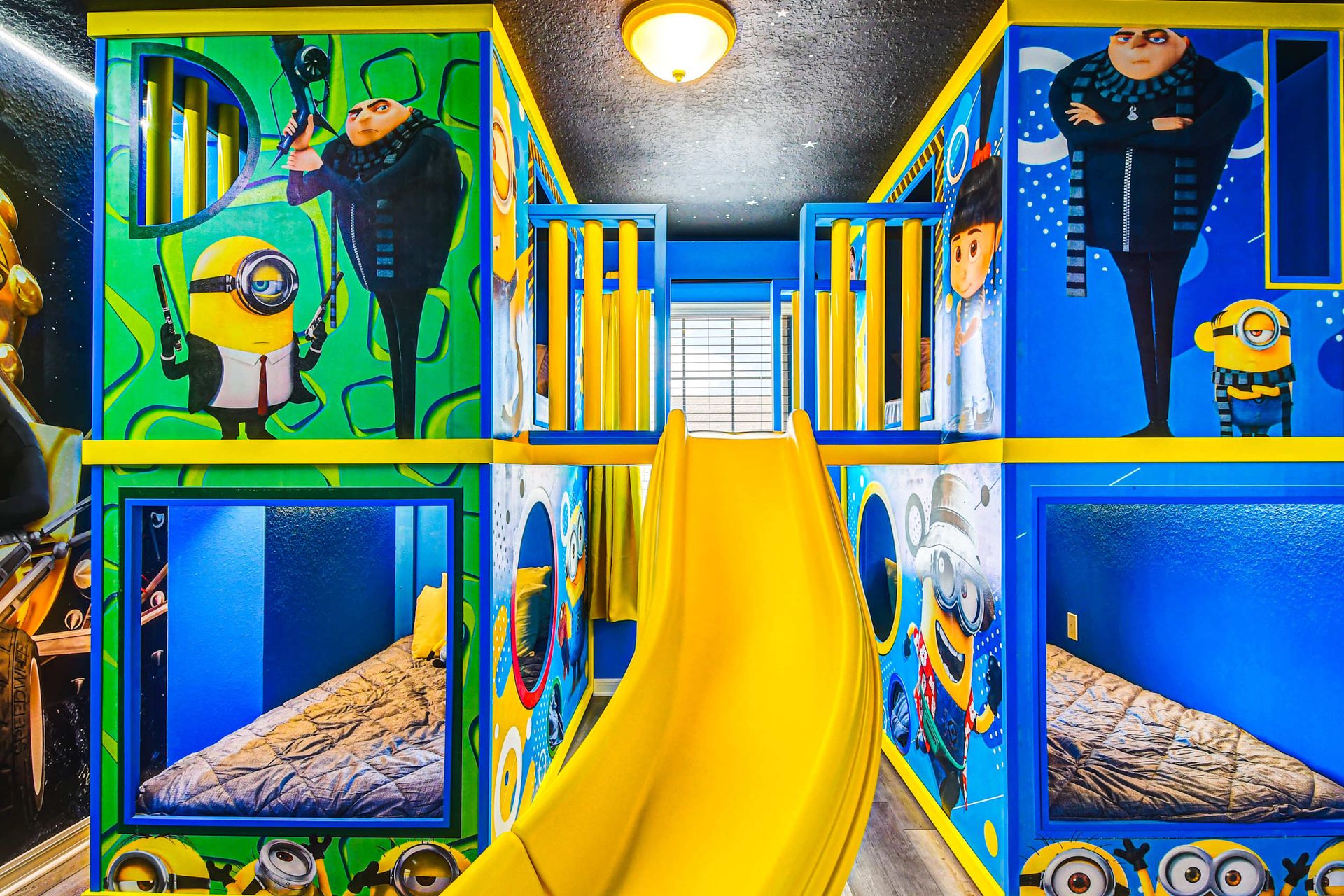 Minion-themed bunk room with slide, murals, and playful beds for the kids.