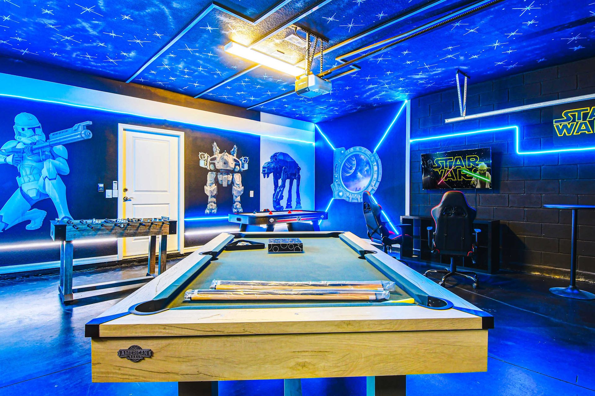 Star Wars-themed game room with pool, foosball, arcade, and galactic wall art.