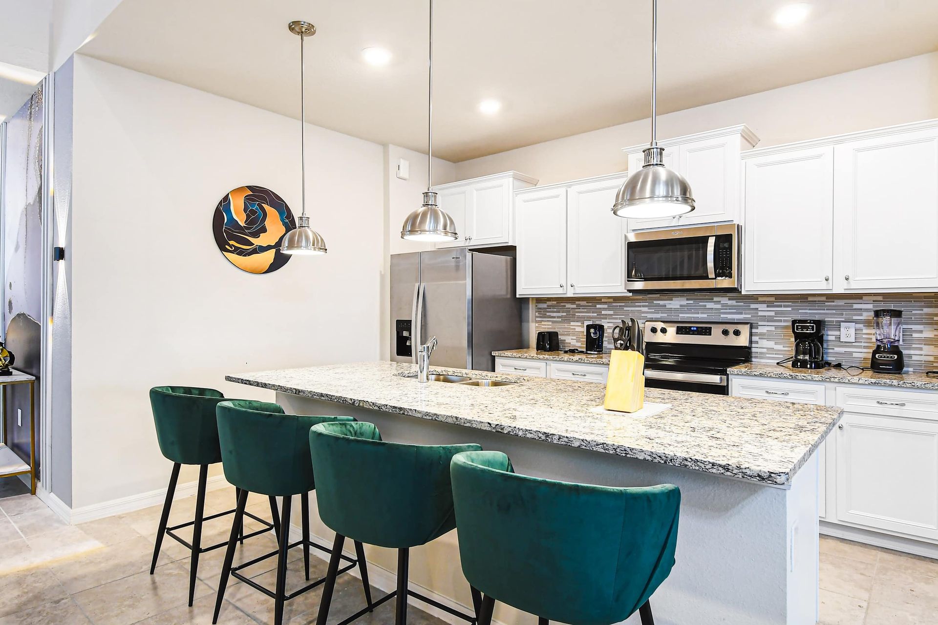Bright, modern kitchen with granite counters, stainless steel appliances, and island seating.