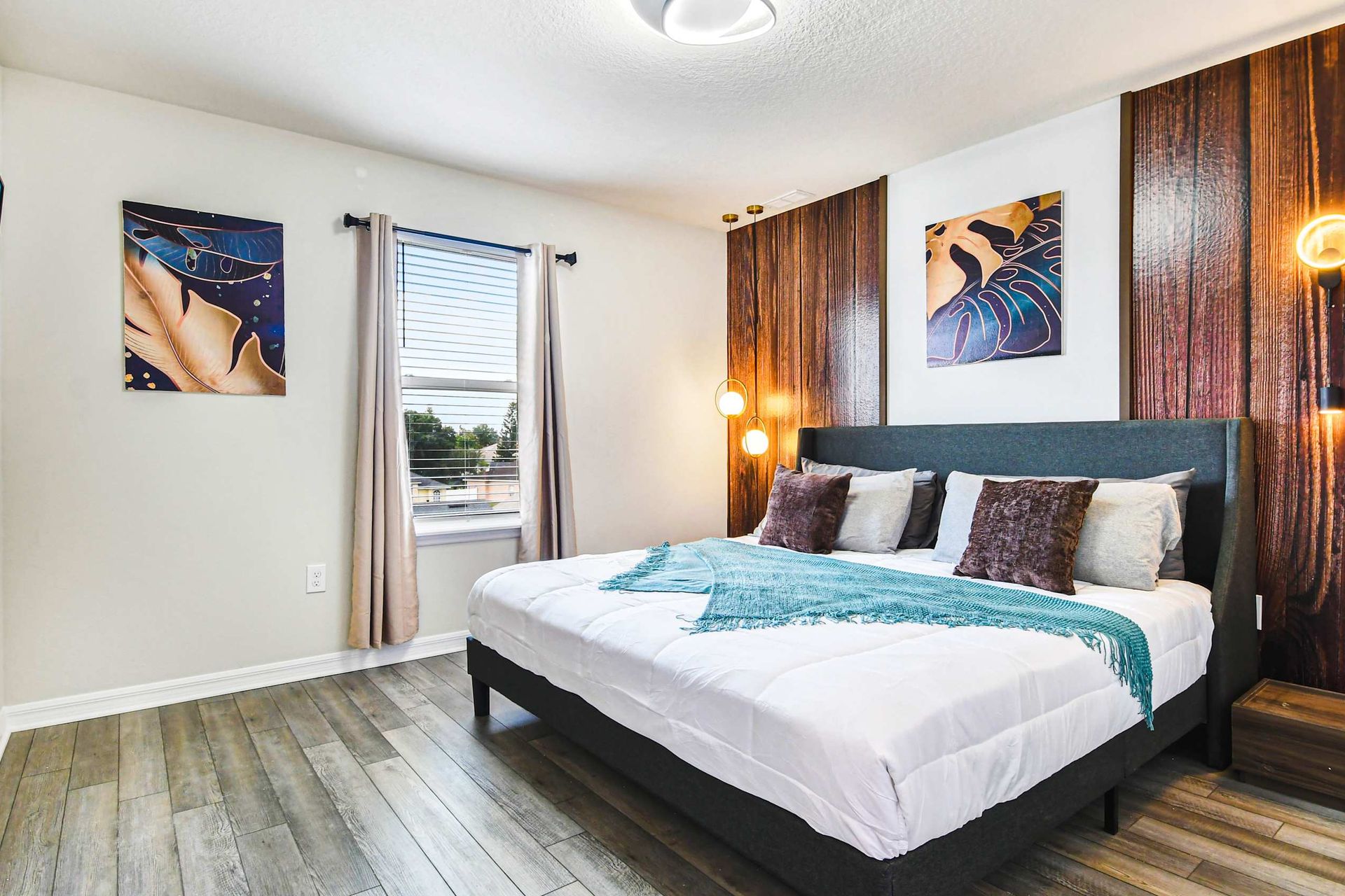 Cozy bedroom with modern decor, wood accents, soft lighting, and wall-mounted TV.