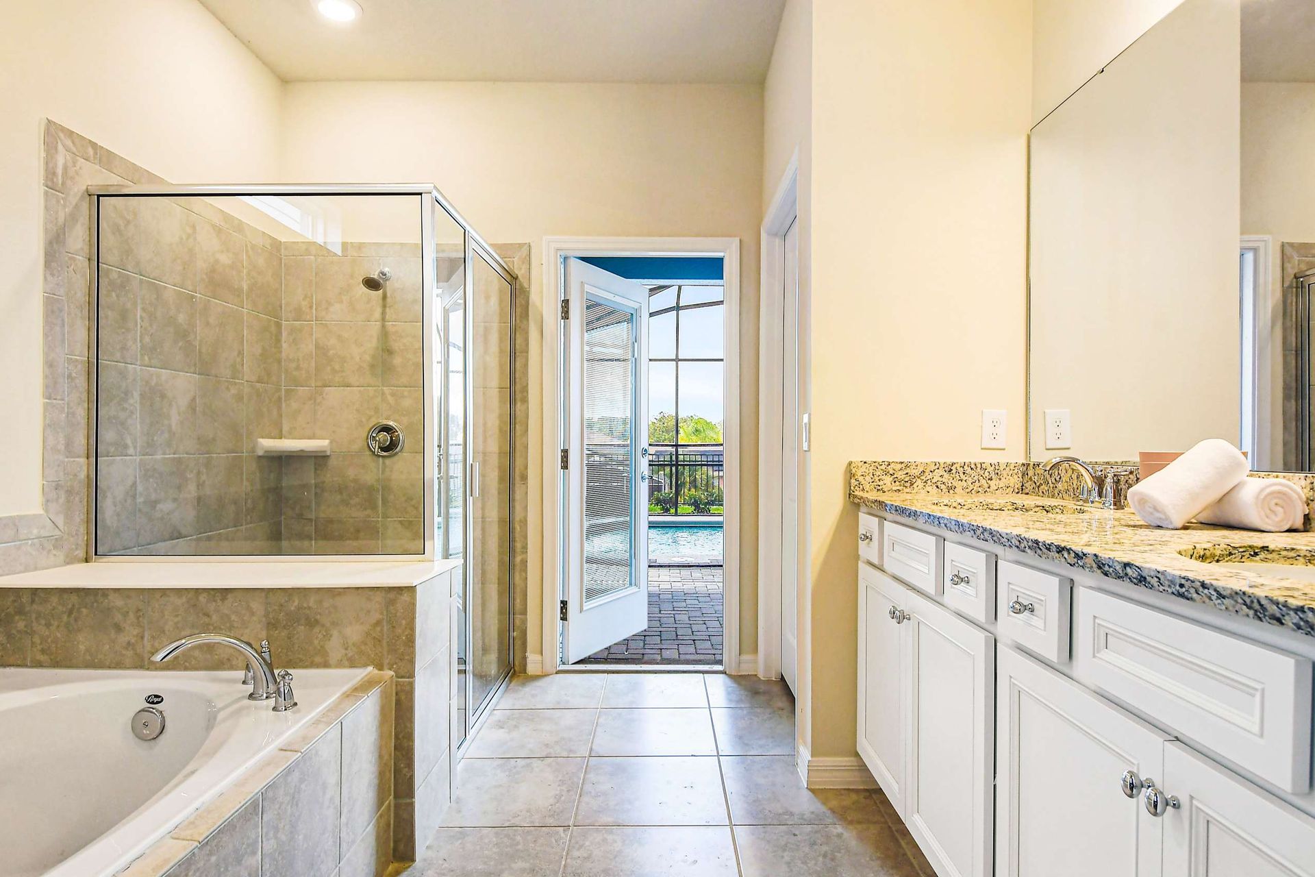 Luxury bathroom with soaking tub, dual vanity, and direct access to the pool.