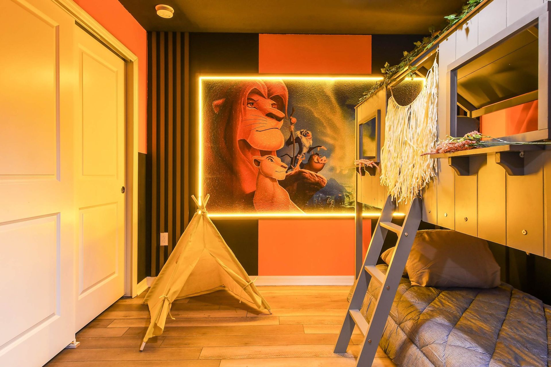 Lion King-inspired bunk room with glowing mural, teepee tent, and jungle vibes.