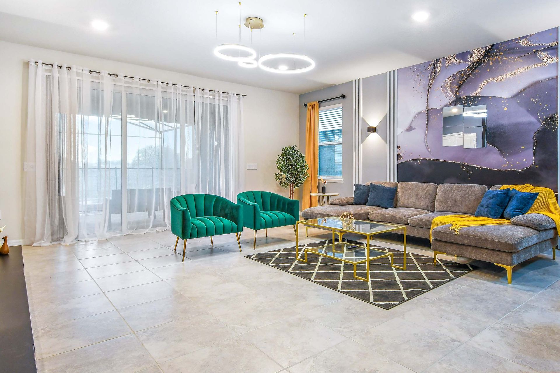 Bright and modern lounge with luxe velvet chairs, abstract art, and patio access.