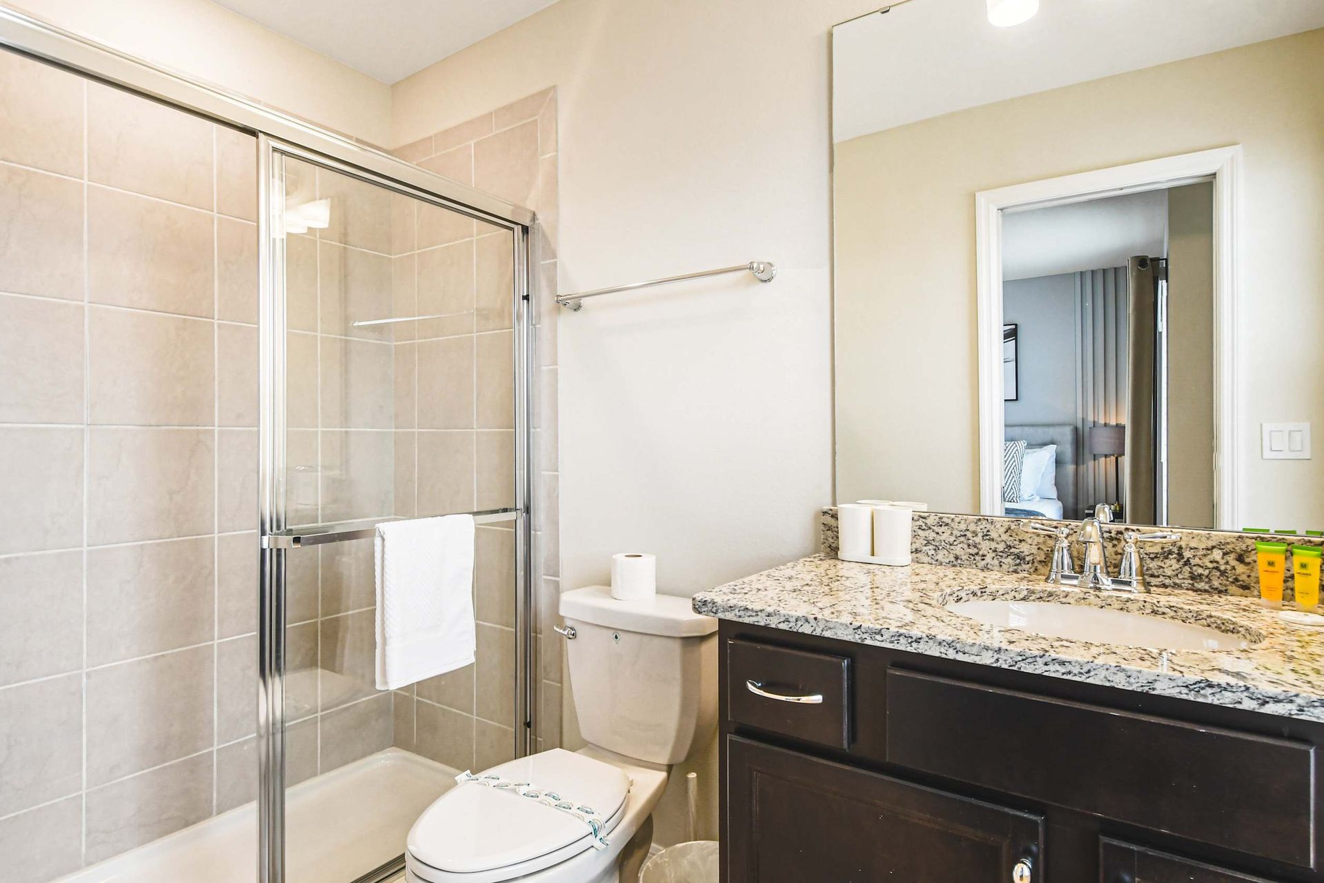 Bright ensuite with granite vanity and glass shower, perfect for relaxing refreshes.