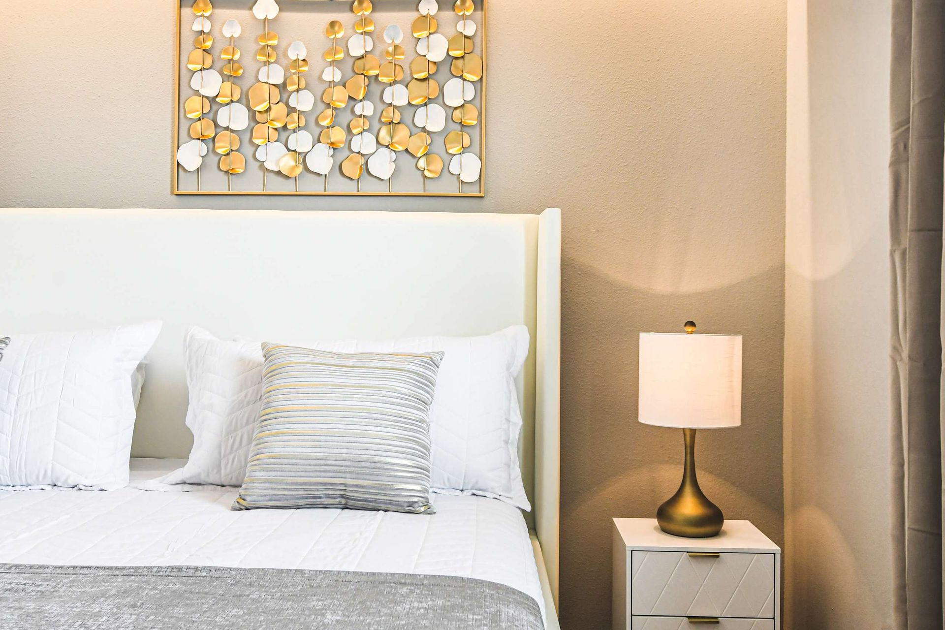 Elegant king room with gold accents, plush bedding, and calming neutral tones.