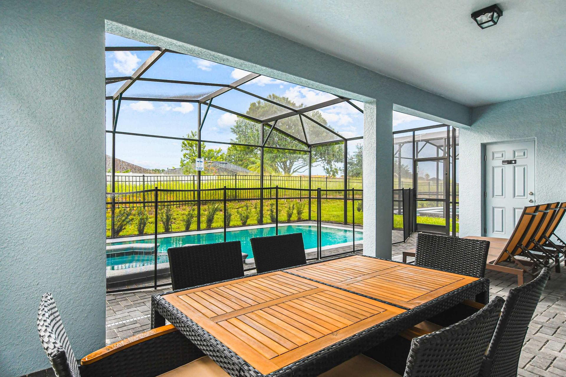 Covered patio with dining and loungers—enjoy meals and poolside relaxation all day!