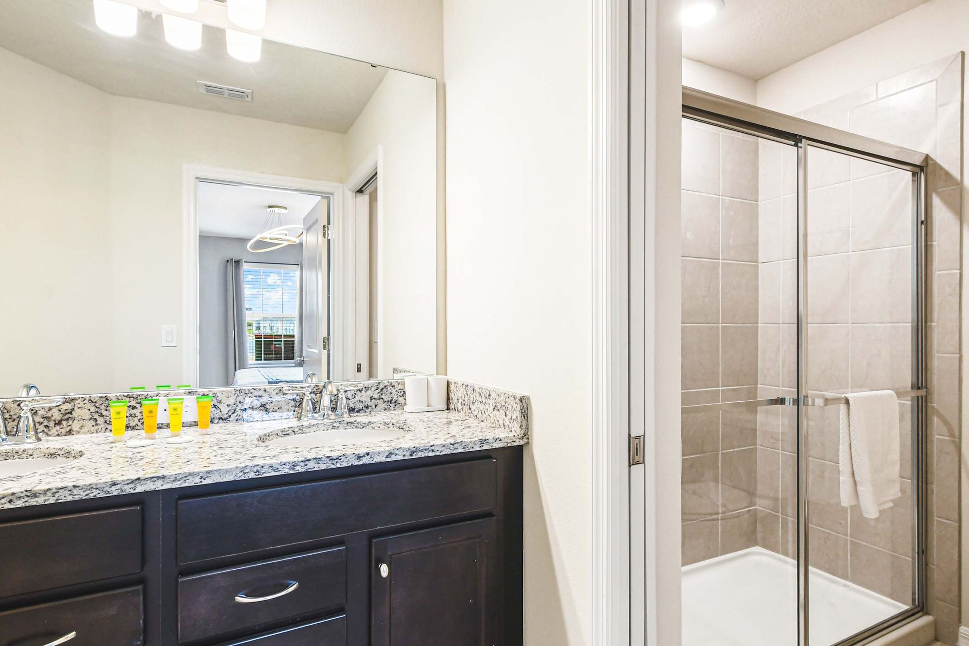 Modern bathroom with granite counters and a walk-in glass shower—spa vibes!