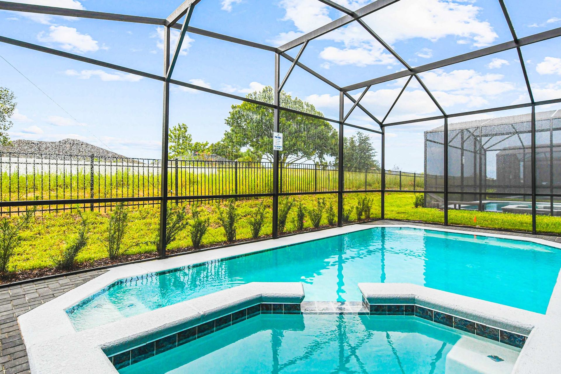 Sparkling screened-in pool and spa with peaceful views—your private outdoor oasis!