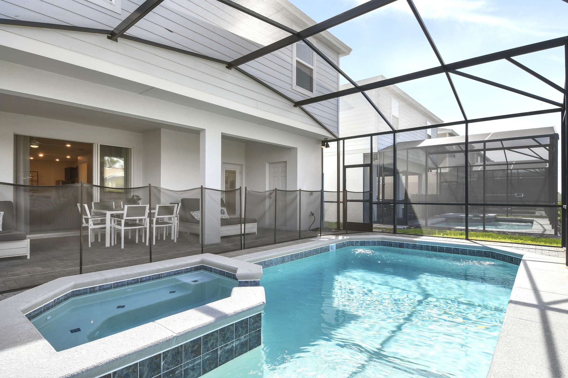 Private screened pool and spa with shaded patio, outdoor dining, and lounge area.