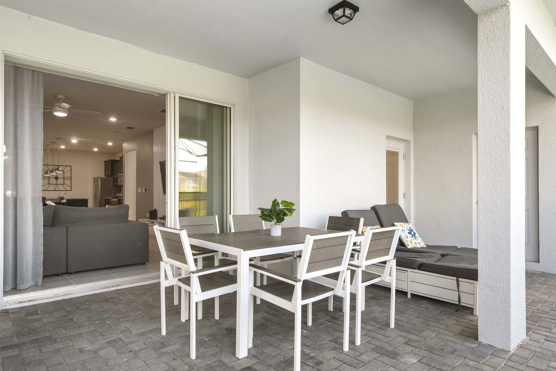 Covered patio with dining space and loungers—perfect for poolside relaxation.