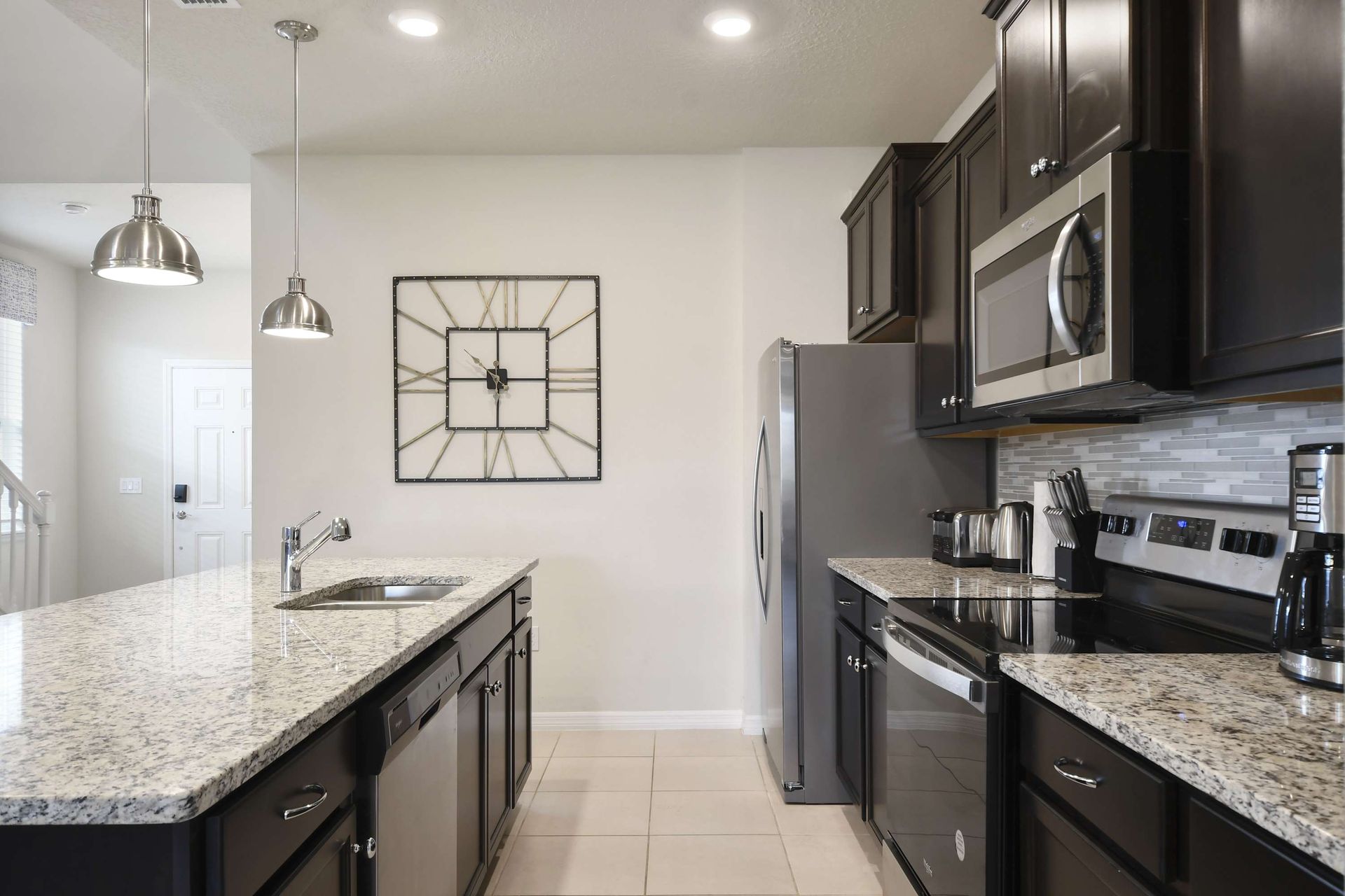 Fully equipped modern kitchen with granite counters and sleek stainless finishes.