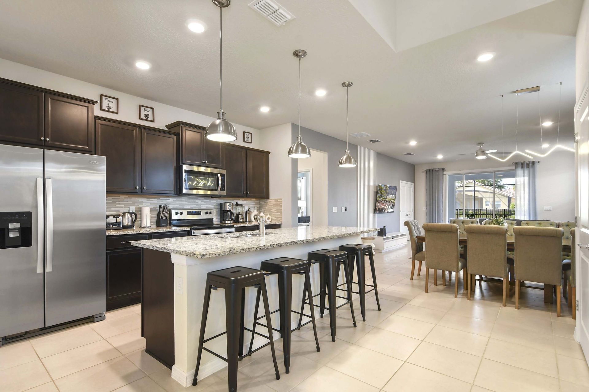 Open-concept kitchen with island seating, stainless steel appliances, and style.