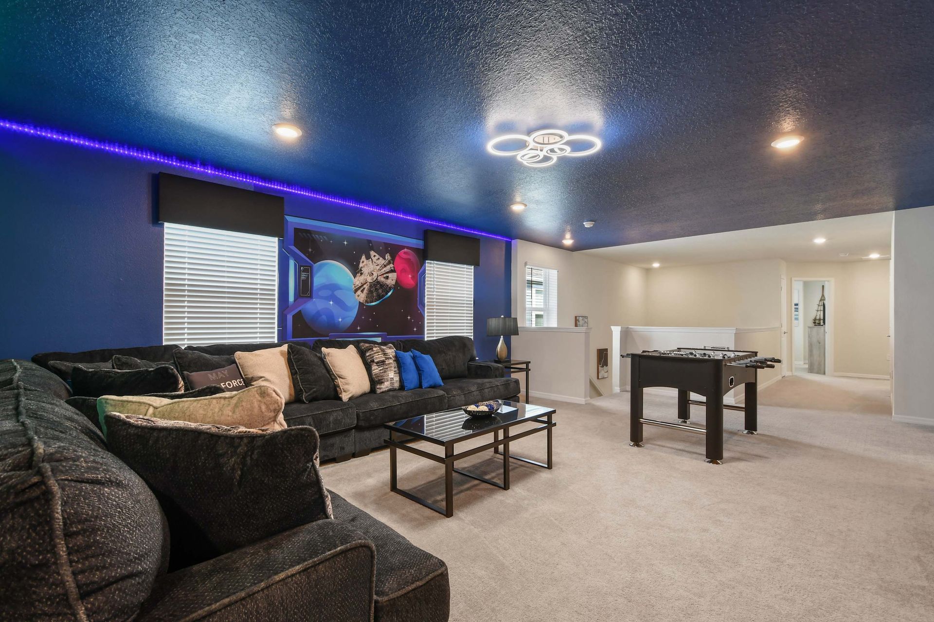 Spacious game loft with galaxy theme, foosball table, and oversized cozy sectional.