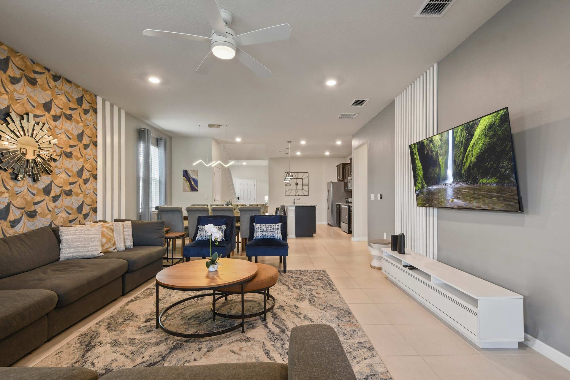 Modern open-concept living with stylish decor, smart TV, and plush seating.