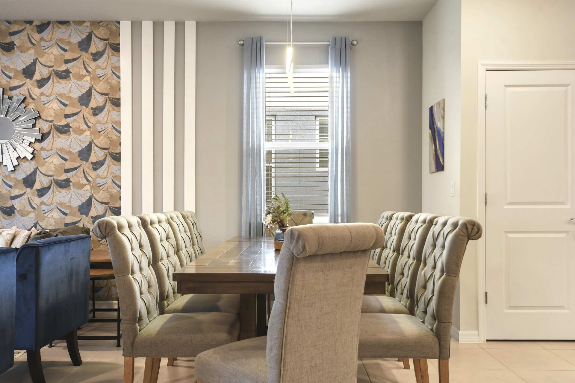 Elegant dining space with seating for eight, tufted chairs, and natural light.