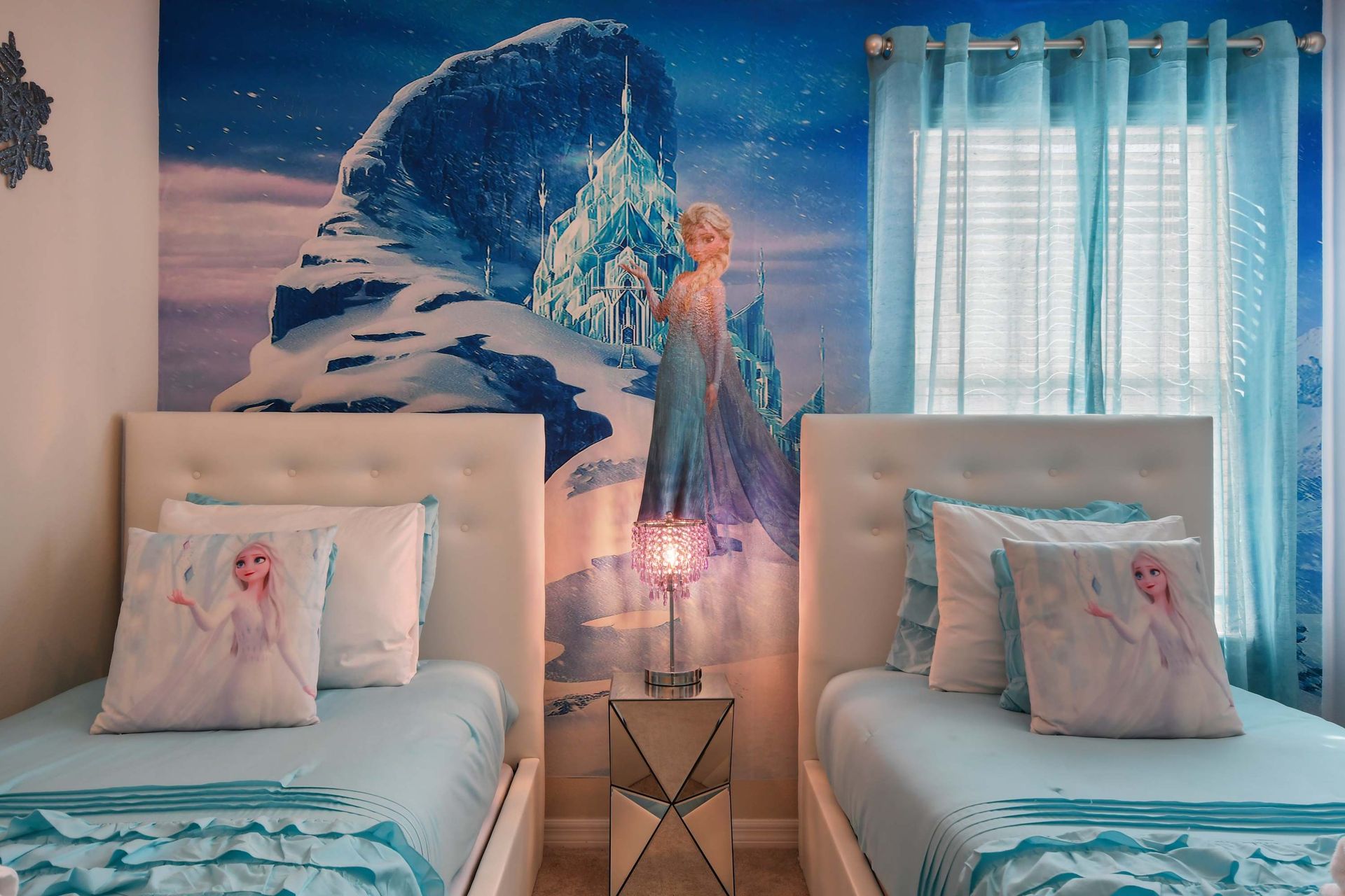 Enchanting Frozen-inspired twin room with icy blue tones and magical wall mural.