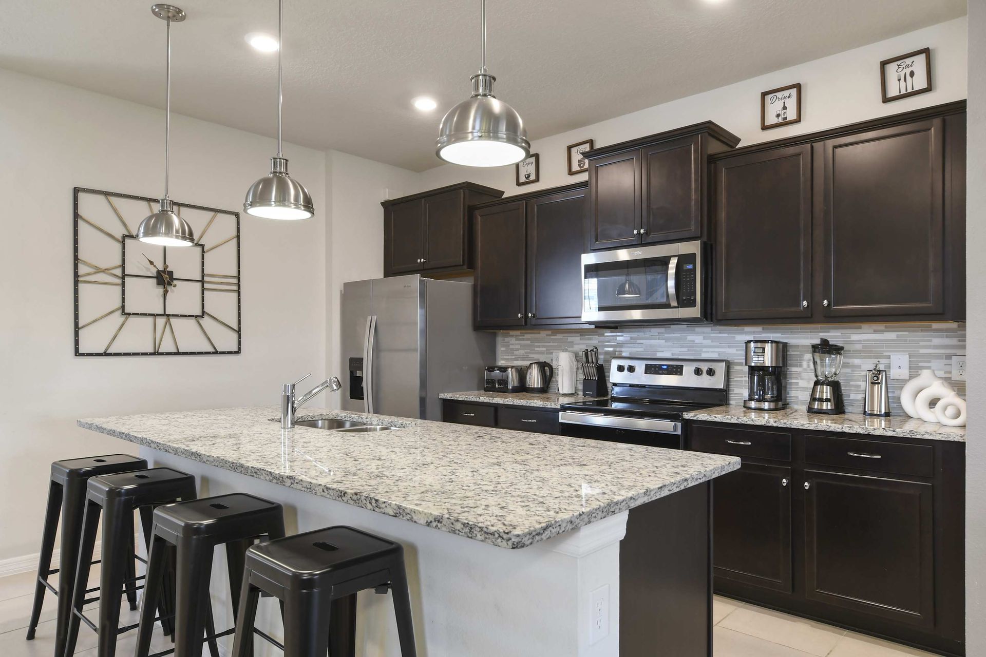 Stylish chef’s kitchen with granite counters, stainless appliances, and seating.