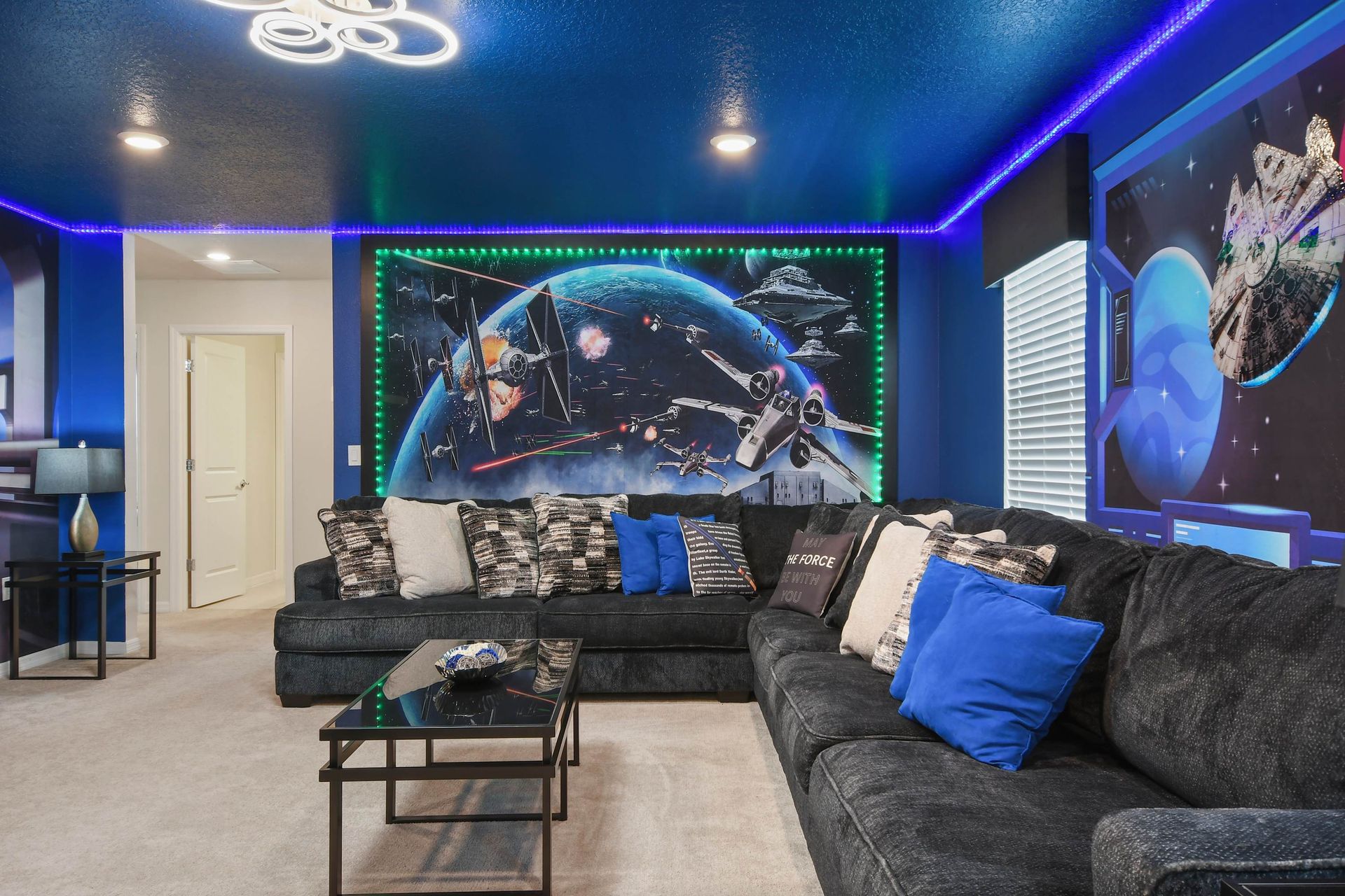 Galactic-themed lounge with oversized sectional, LED glow, and epic space murals.