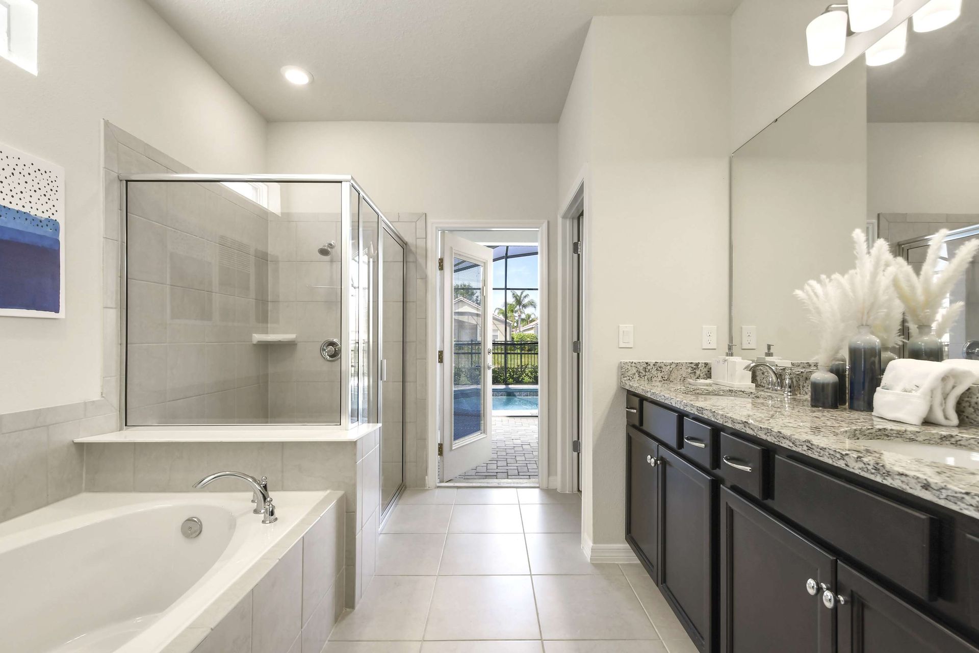 Luxurious en-suite bath with soaking tub, walk-in shower, and poolside access.