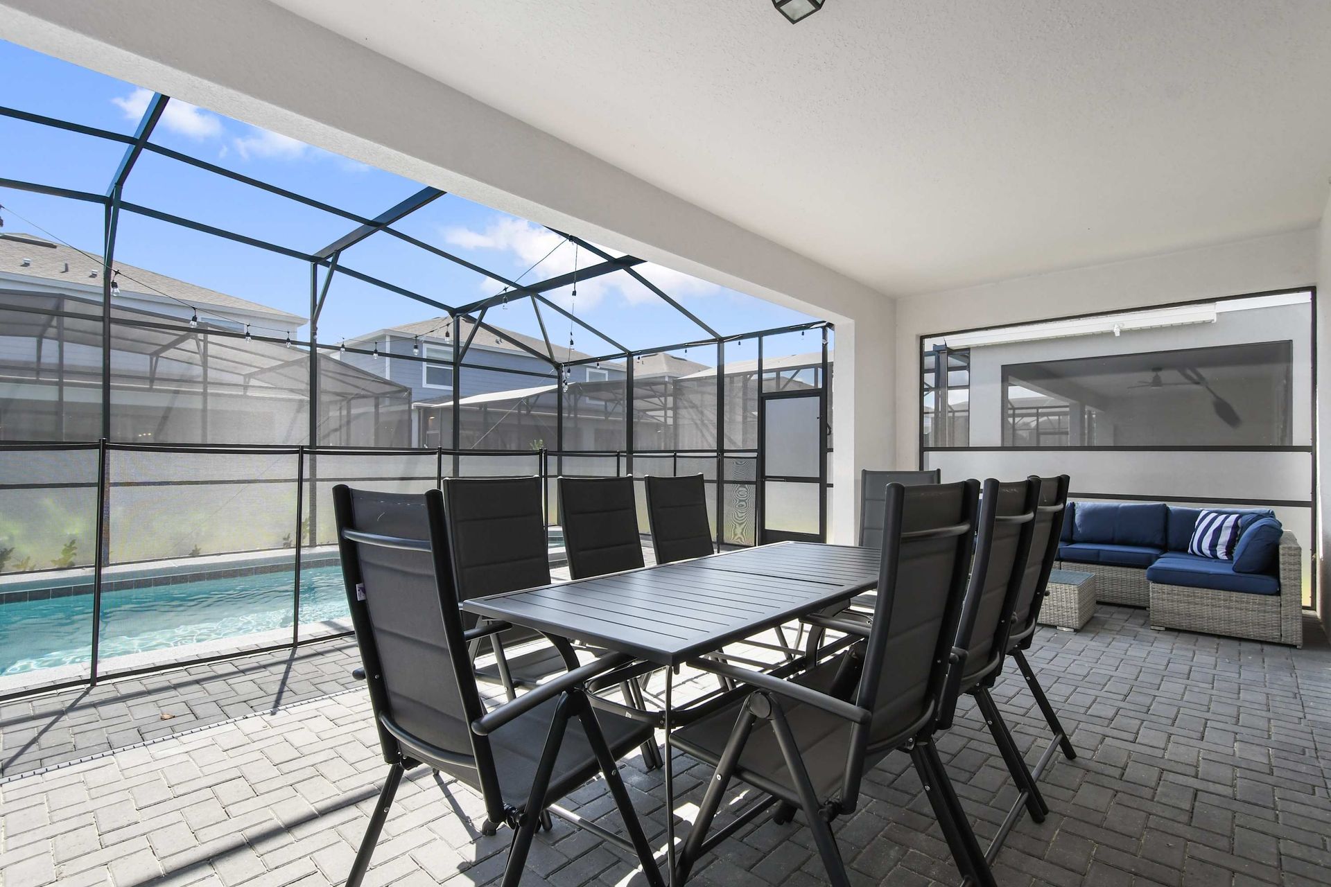 Spacious outdoor dining and lounge area, perfect for meals and relaxation by the pool.