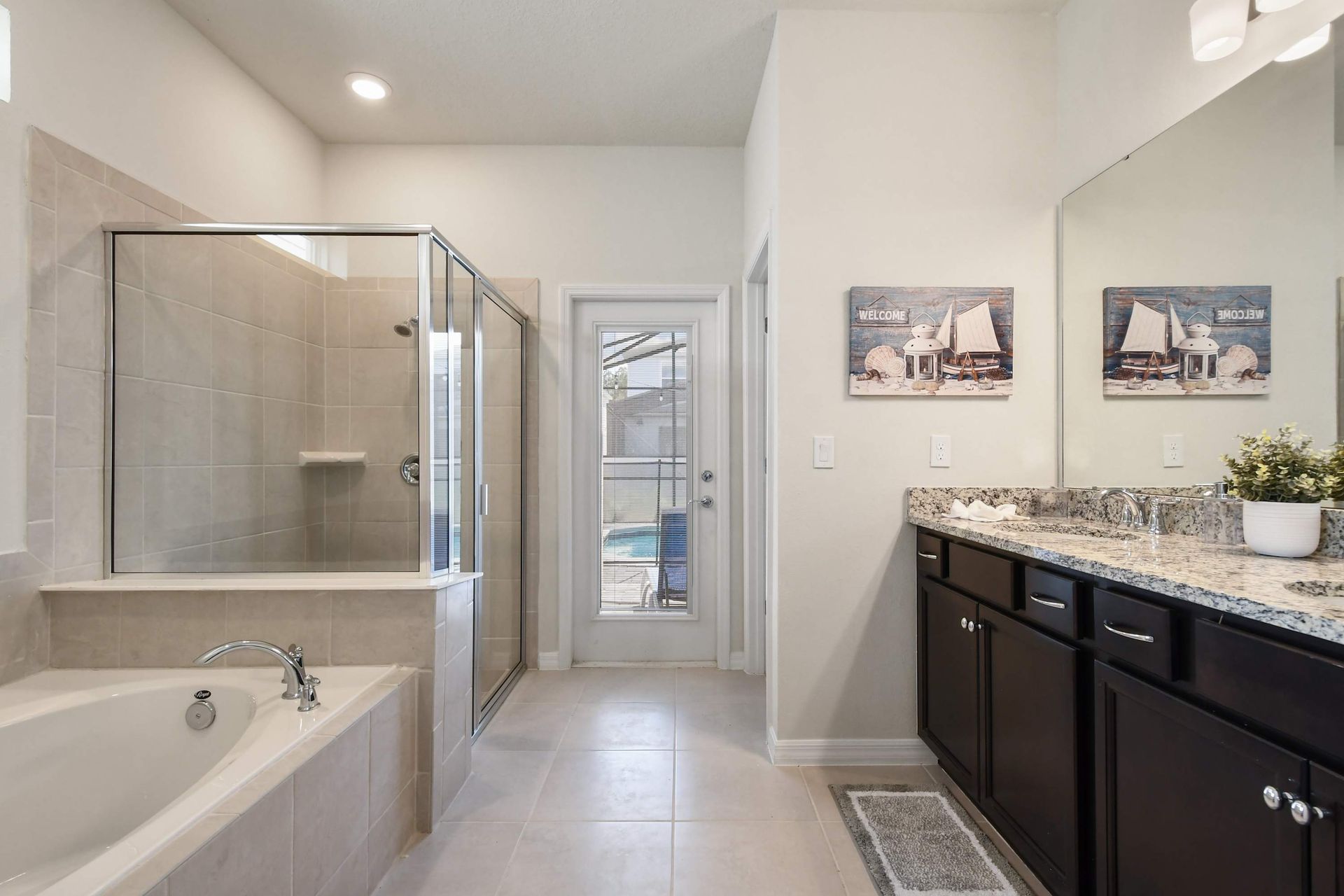 Spacious bathroom with a relaxing tub, shower, and direct access to the pool.
