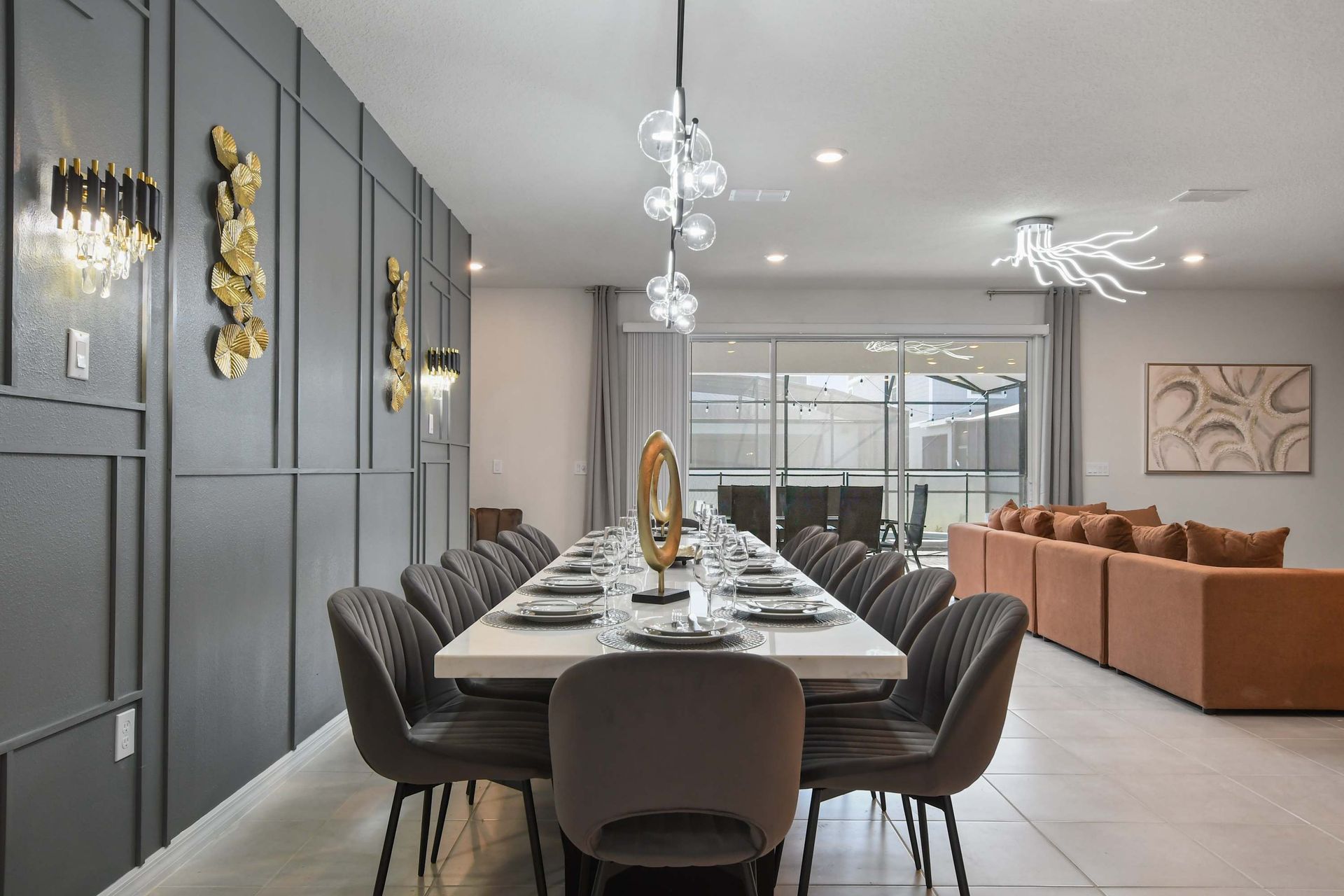 Chic dining area with statement lighting, modern art, and seating for large groups.