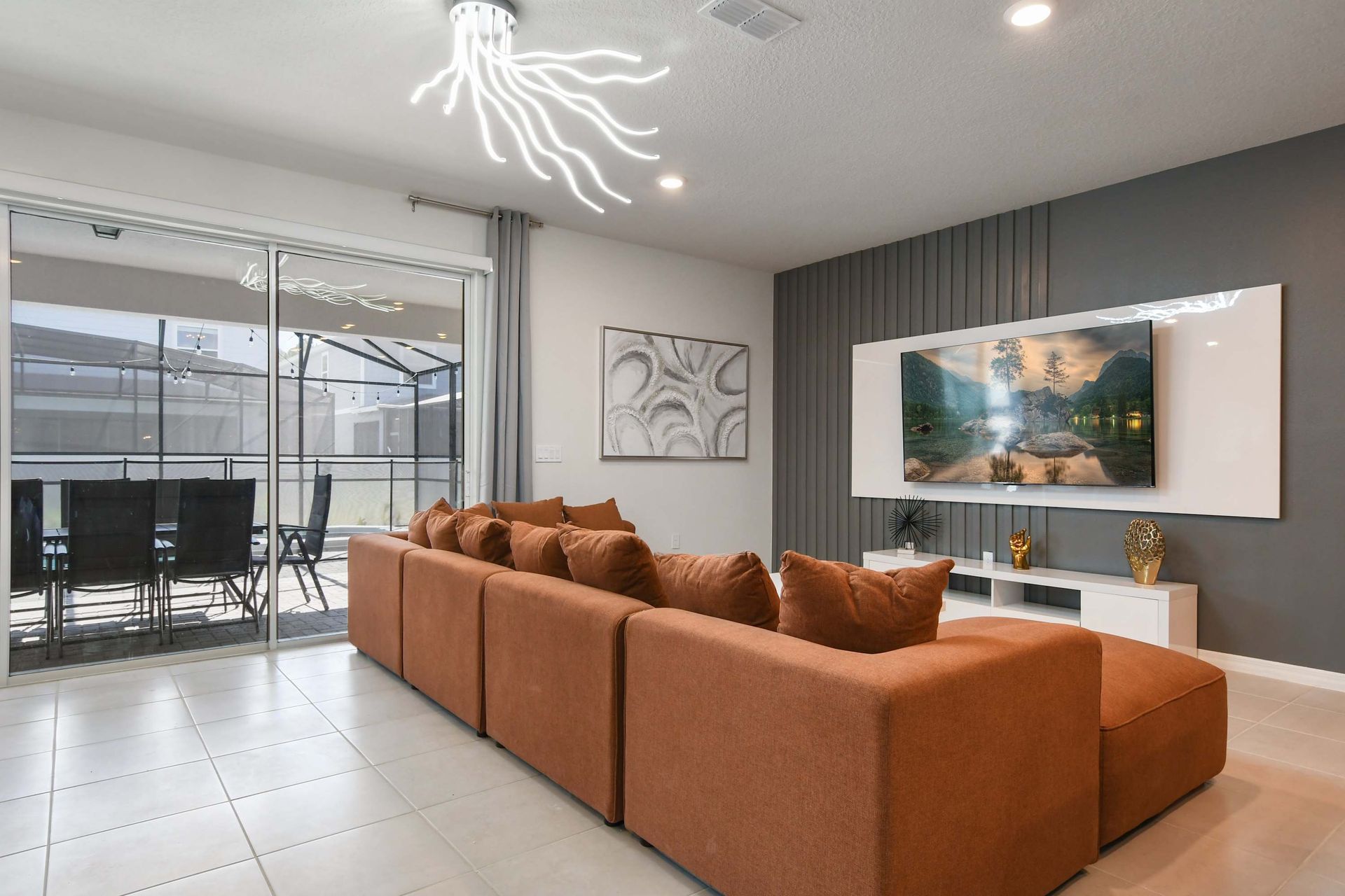 Spacious modern living room with bold sofa, sleek TV wall, and patio access.