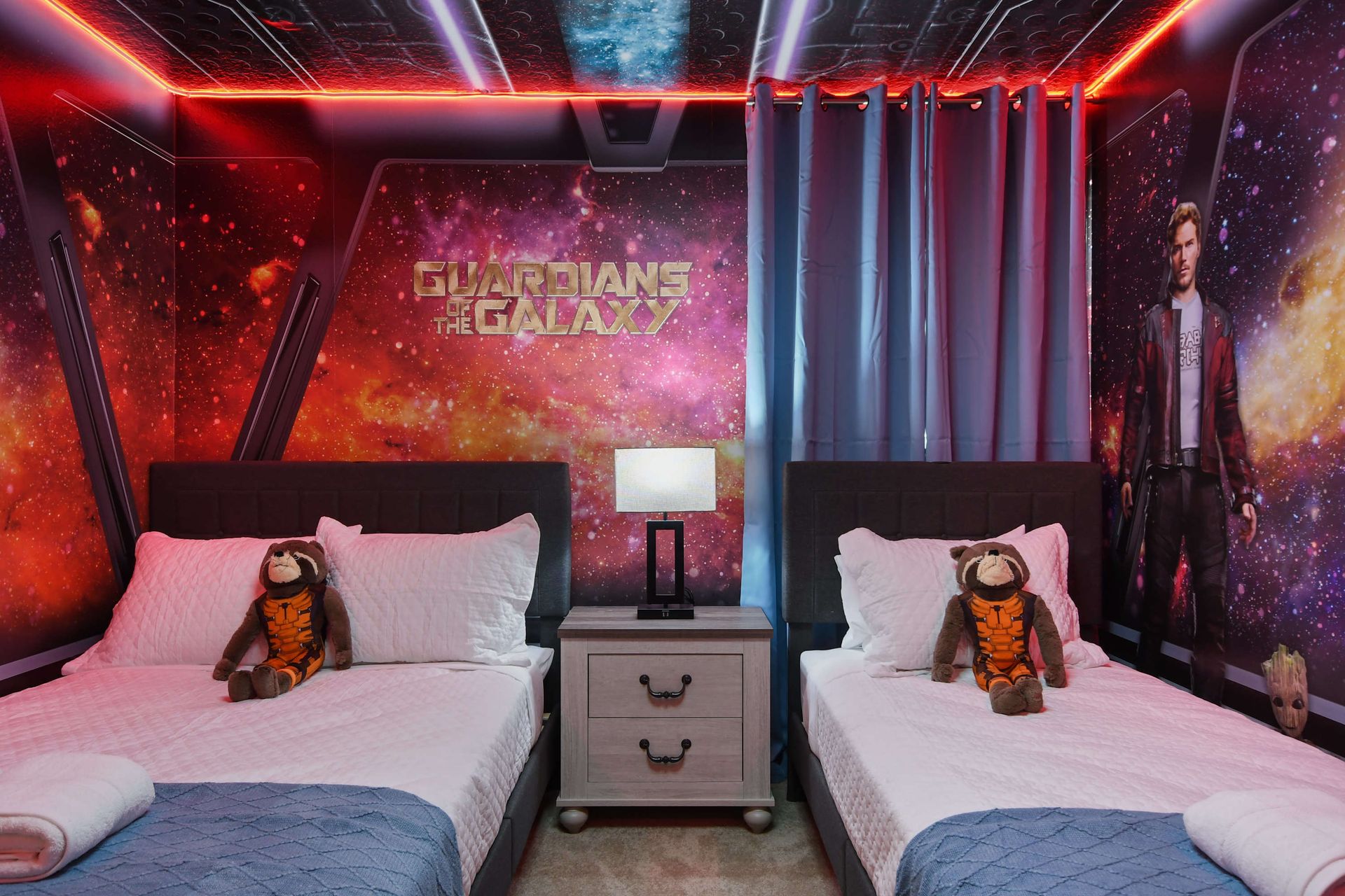 Guardians of the Galaxy-themed room with twin beds, starry murals, and galactic glow.