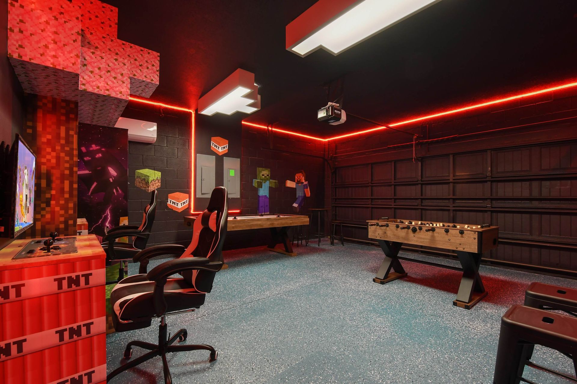 Minecraft-inspired game garage with arcade setup, foosball, and glowing red lights.