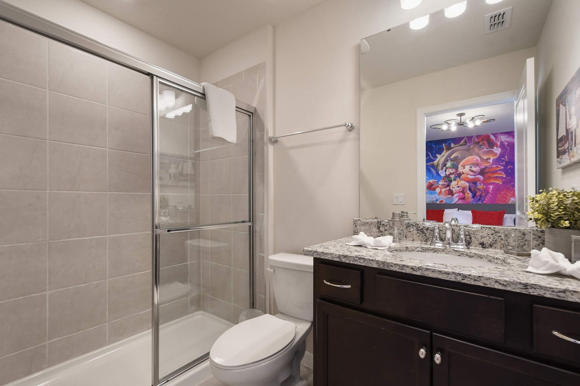 Charming bathroom with modern finishes, featuring a fun and vibrant themed room behind.