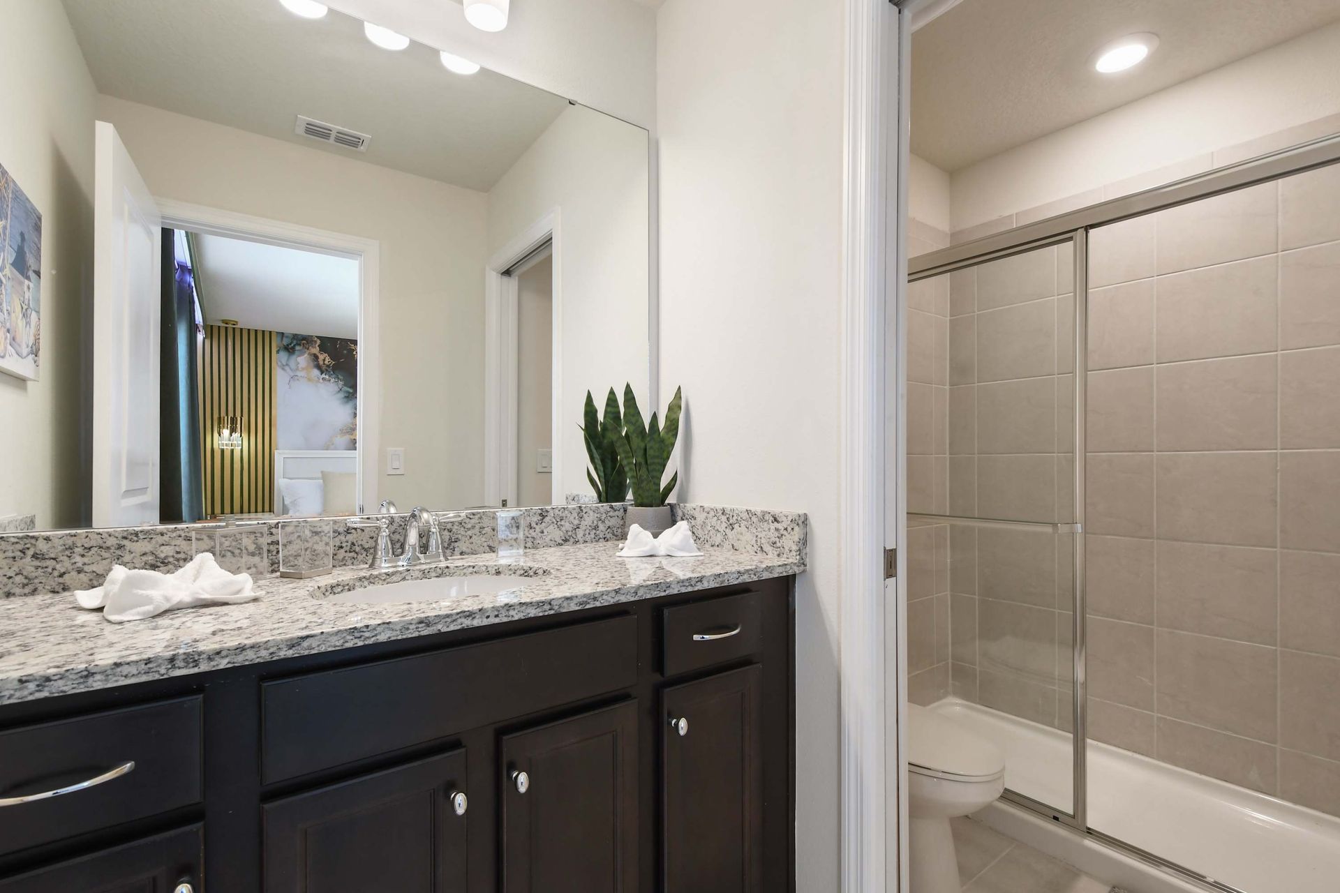 Clean and modern bathroom with a sleek granite countertop and shower.