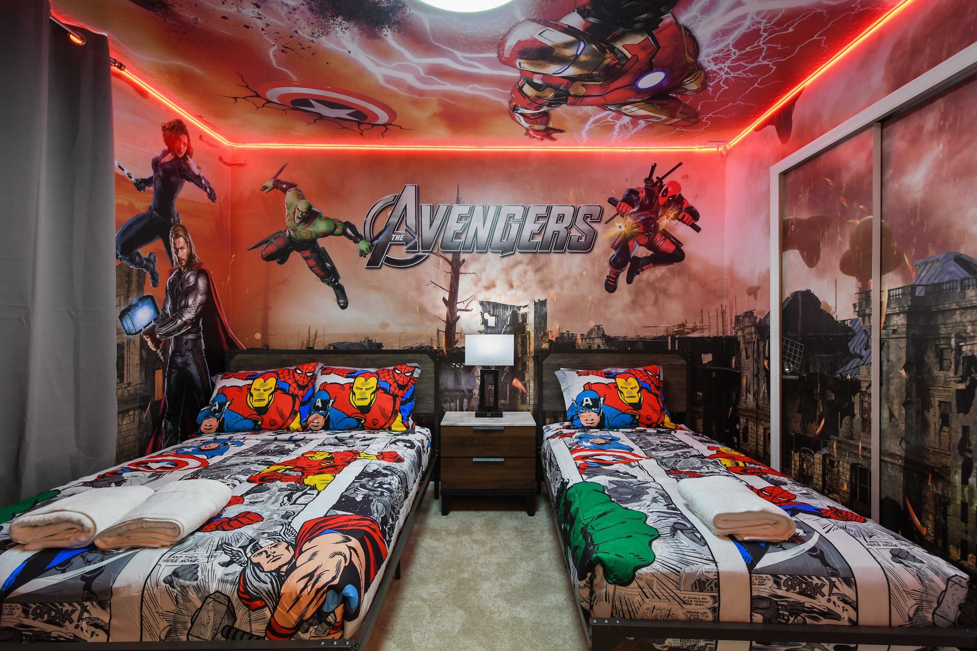 Bold Avengers-themed twin room with dynamic superhero murals and comic-style bedding.