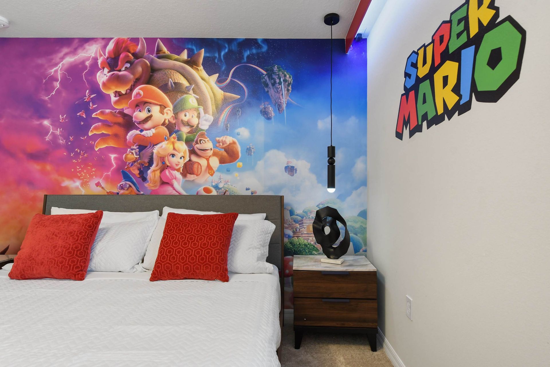 Colorful Super Mario room with character mural, modern lighting, and cozy king bed.
