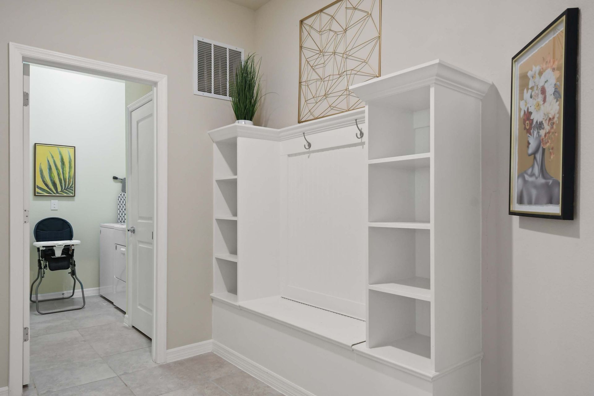 Stylish mudroom with built-in storage and easy access to laundry and essentials.