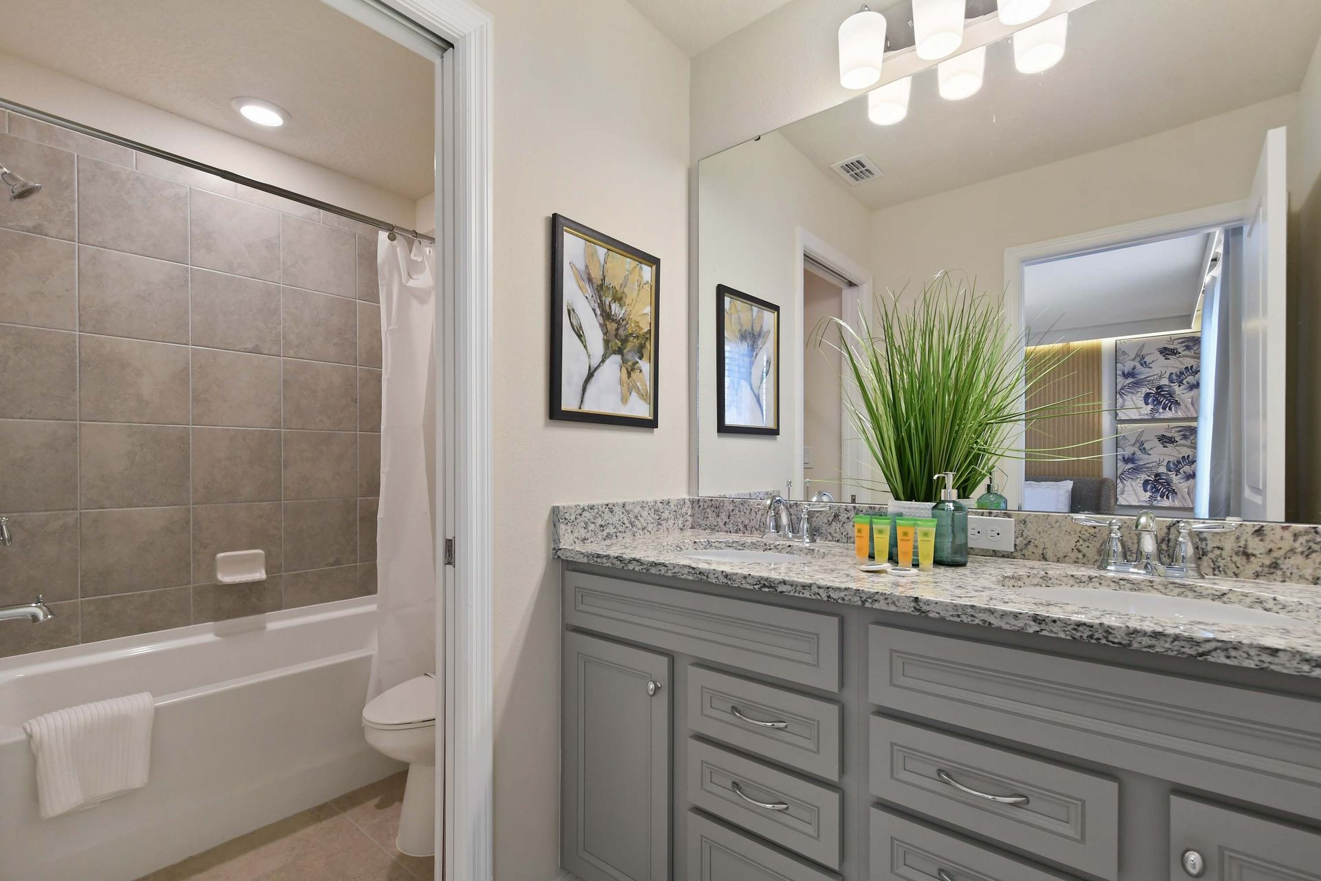 Bright bathroom with dual sinks, granite counters, and tub—perfect for families.