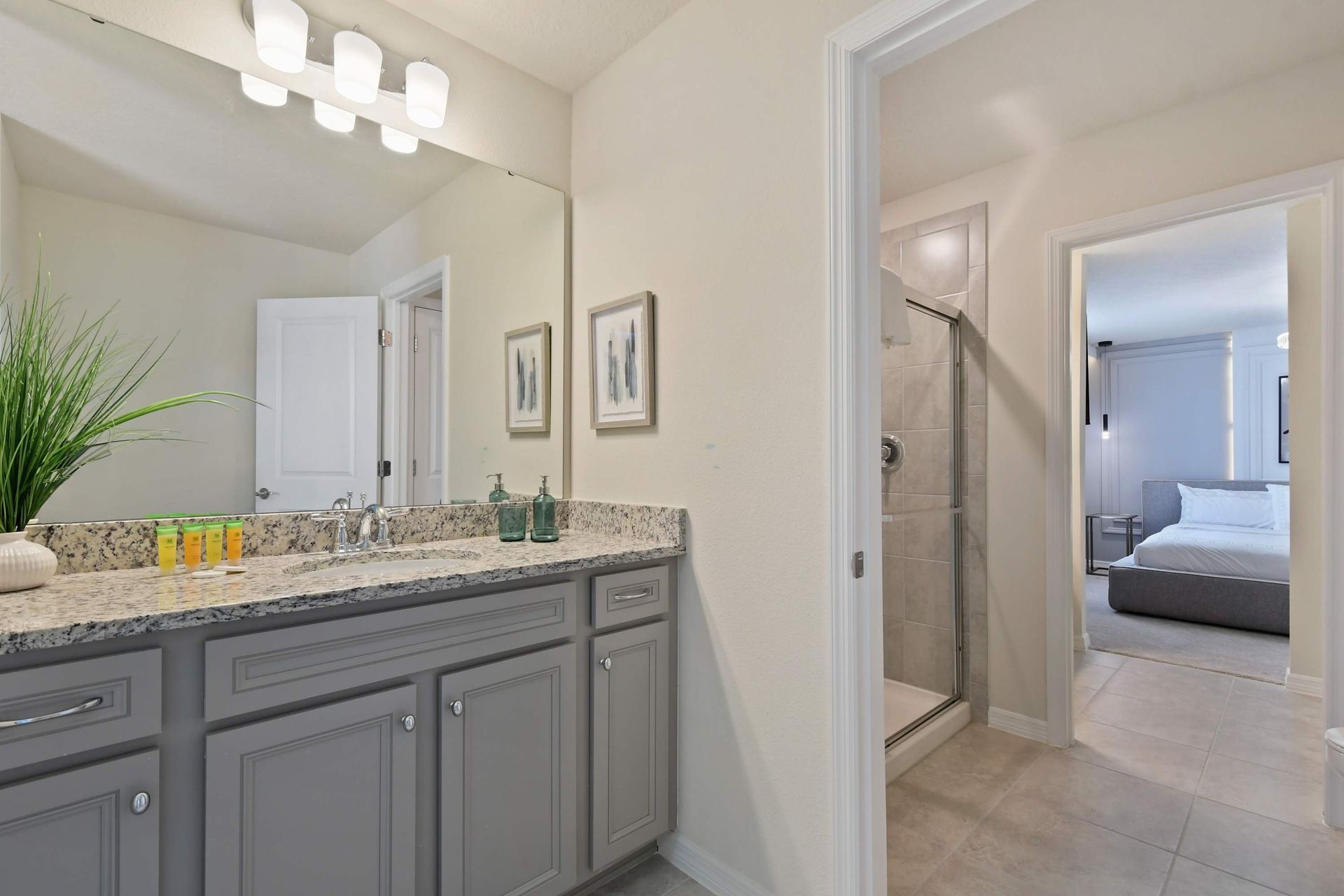Elegant bathroom with dual sinks, granite counters, and direct bedroom access.