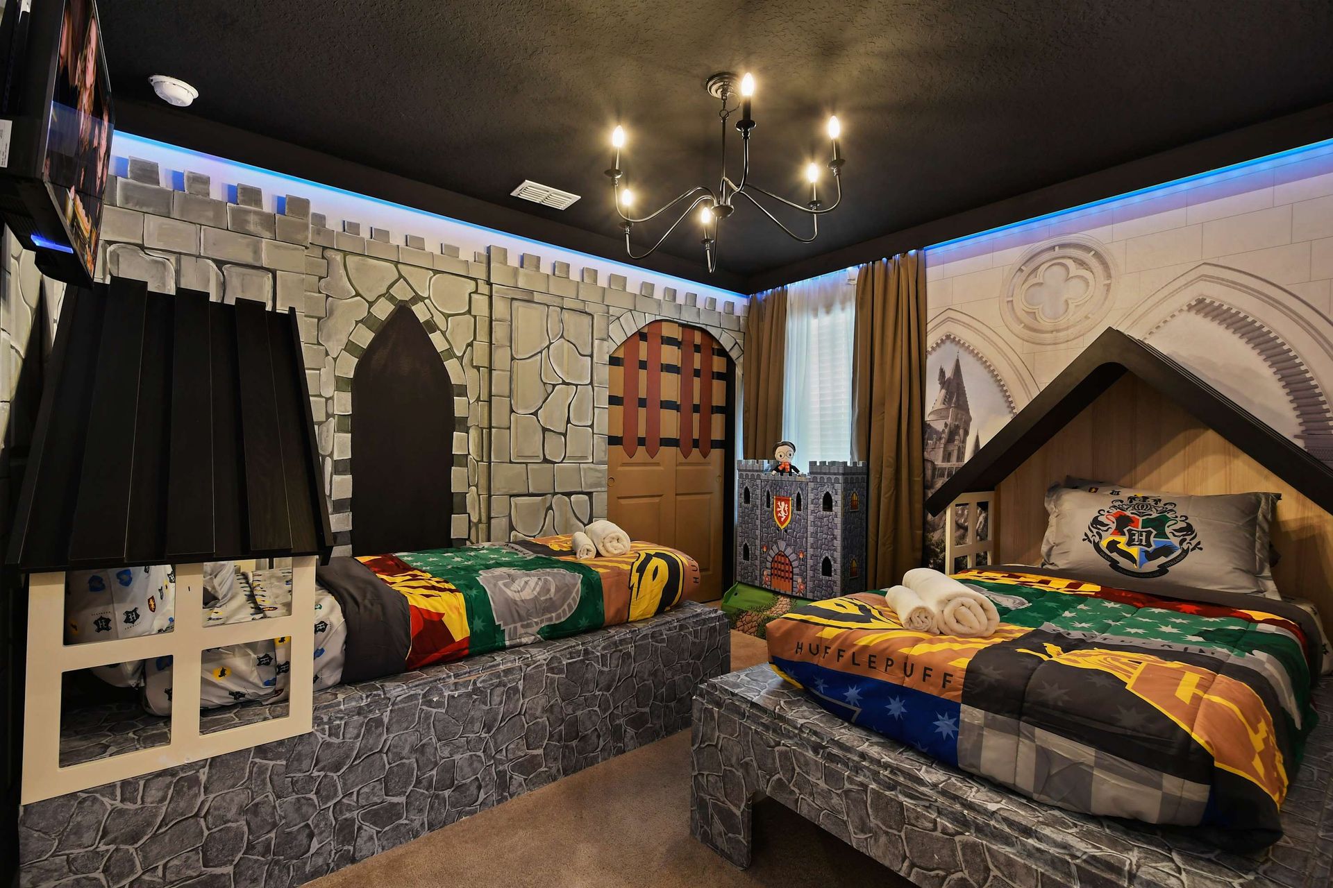 Magical castle-themed room with twin beds, house banners, and spellbinding decor.